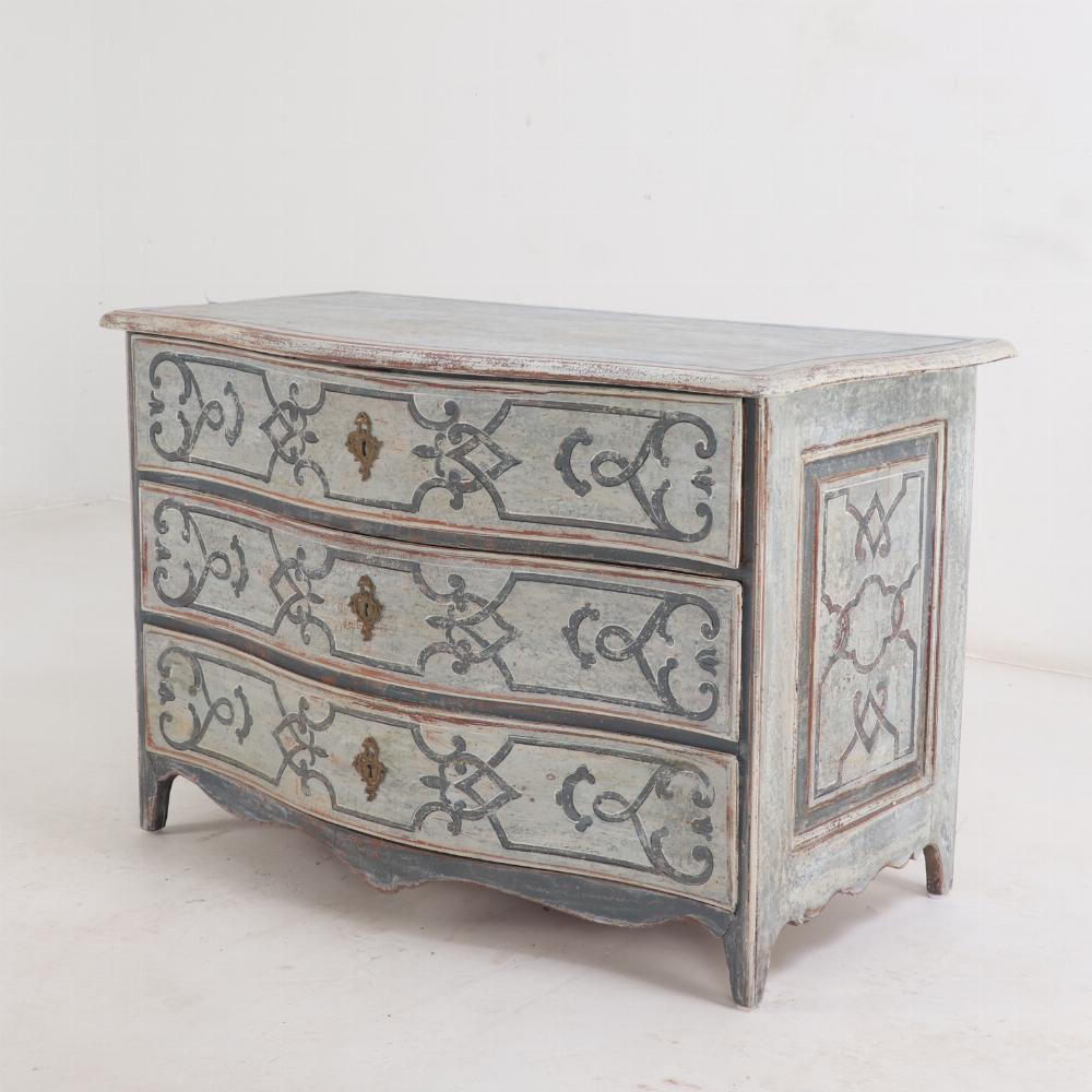 Questa bellissima commode a tre cassetti risale al XVIII secolo (probabilmente francese) e presenta una sottile facciata anteriore a serpentina. Tutti i cassetti e i lati sono decorati con arabeschi dipinti e disegni lineari. La parte anteriore e i