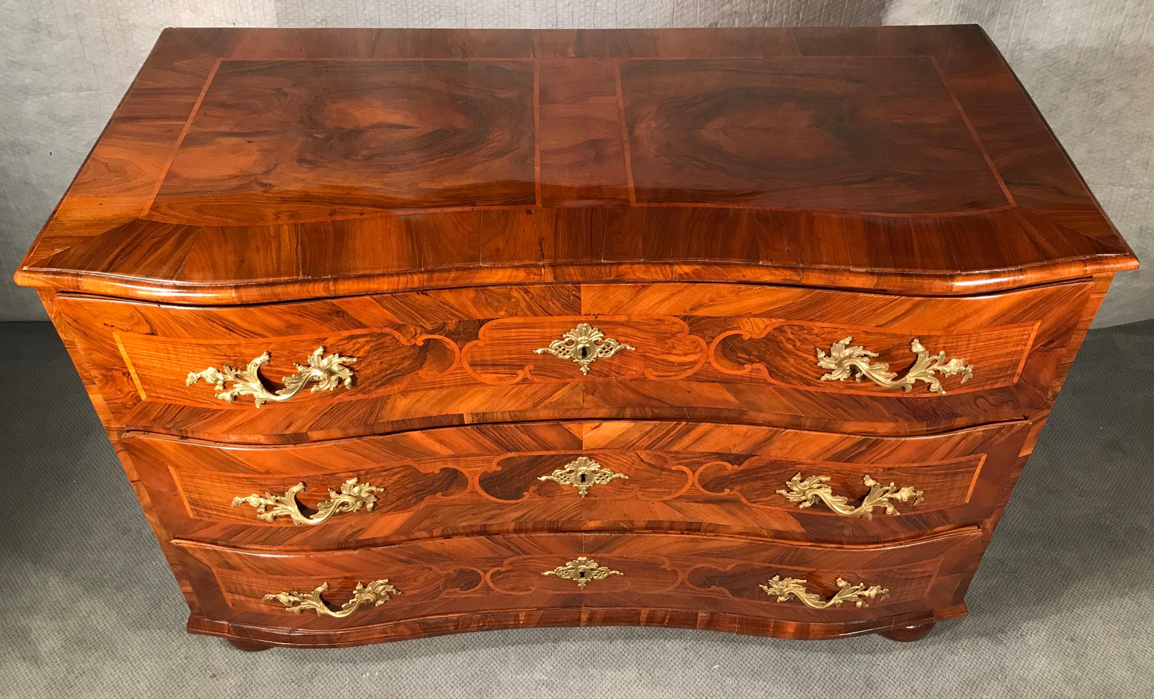 Outstanding south German Baroque chest of drawers, made, circa 1750. The cabinetmaker used different walnut grains and cherrywood for his marquetry. Beautiful brass fittings. The commode is in very good refinished condition. It has been French