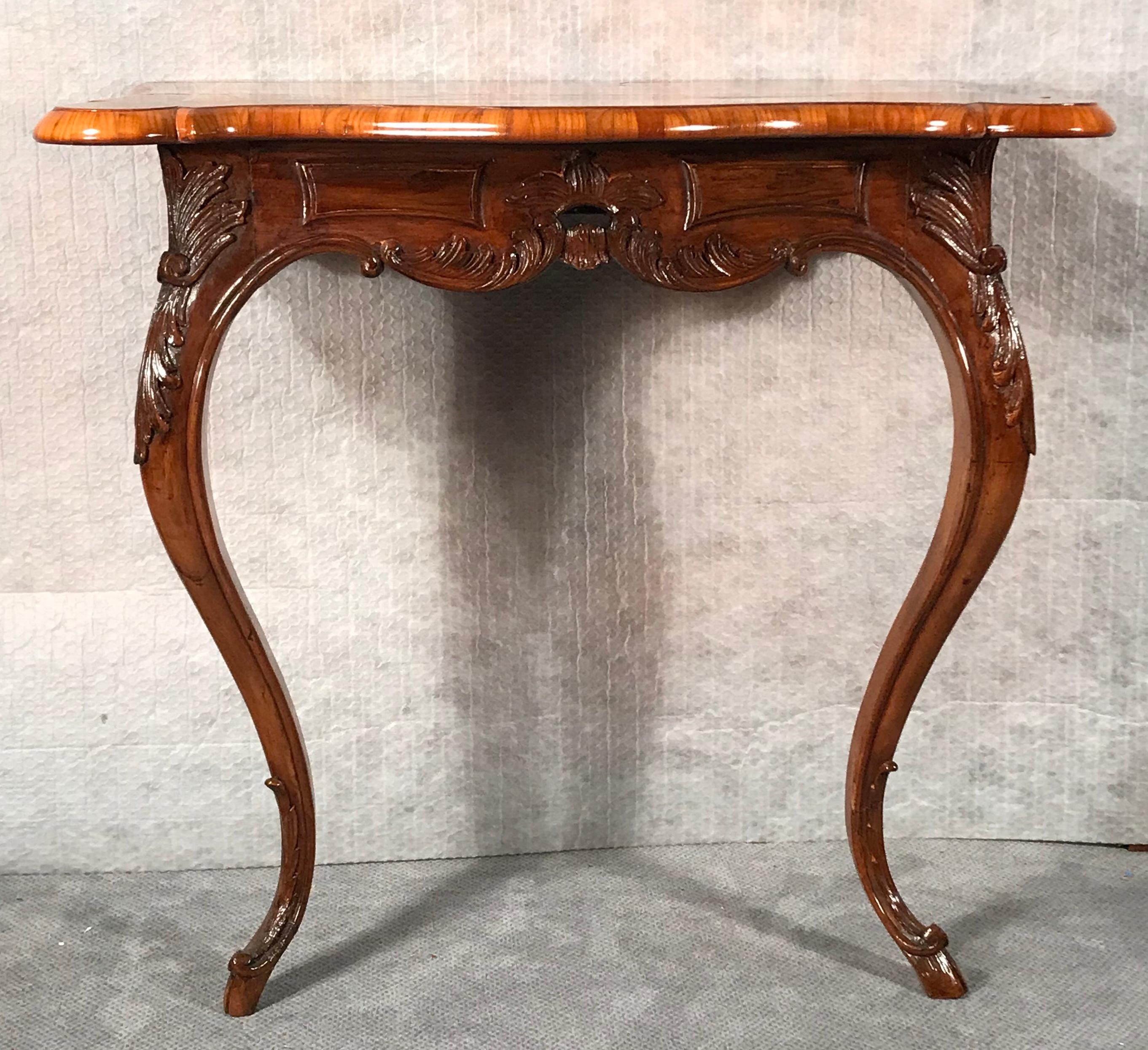 Original 18th century Baroque console table, South Germany 1750-1760, walnut and cherry veneer with bird’s-eye maple marquetry on the top. The walnut base has hand carved acanthus leave decorations. The console table is in very good refinished