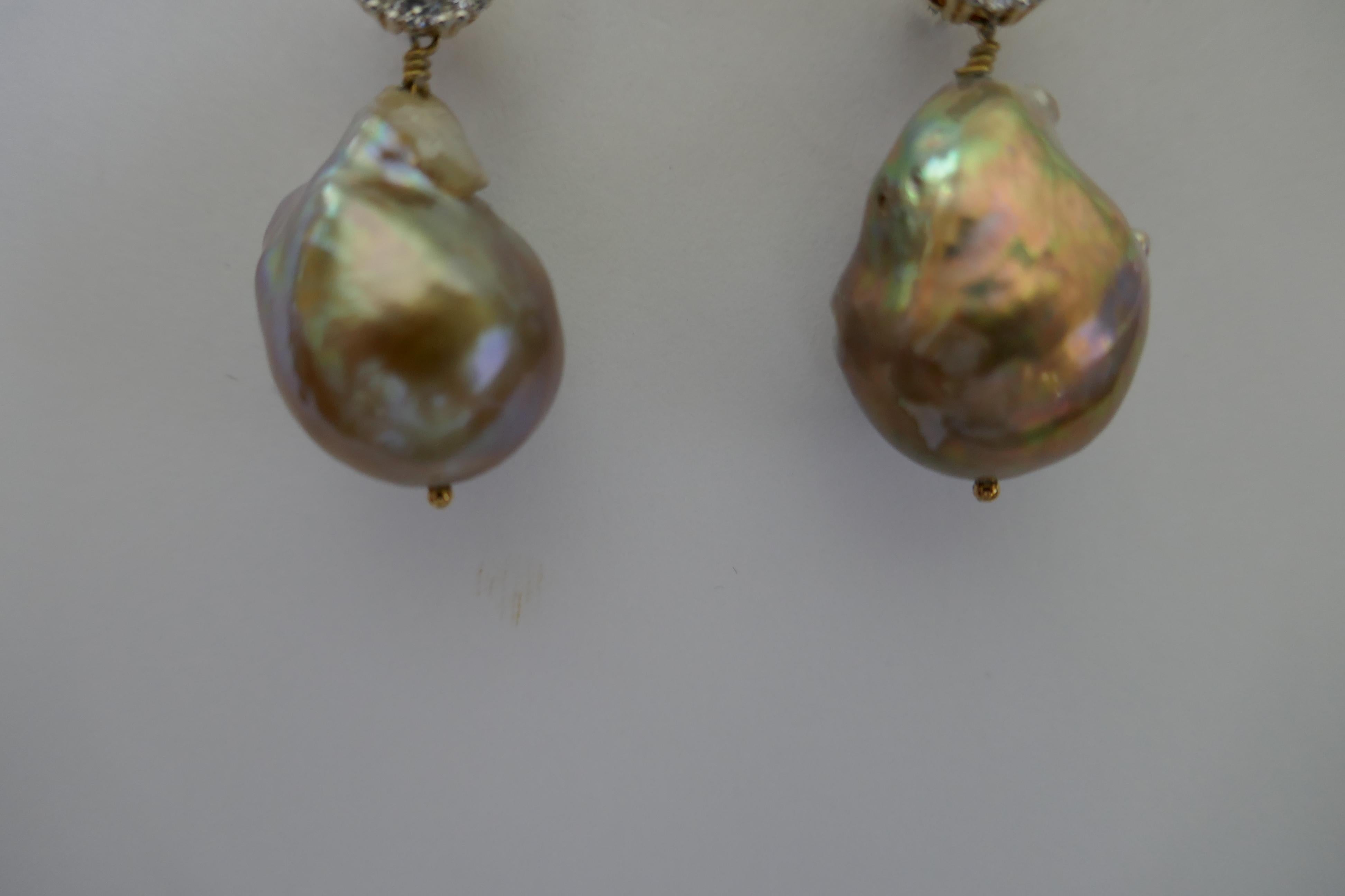 The earrings have a baroque cultured pearls in golden tones as seen in the picture. The size of the pearls is approximately  16mm  x 24mm  The post are screw back but rubber backs may be used. The earrings are 1 3/8  inches long. They look beautiful
