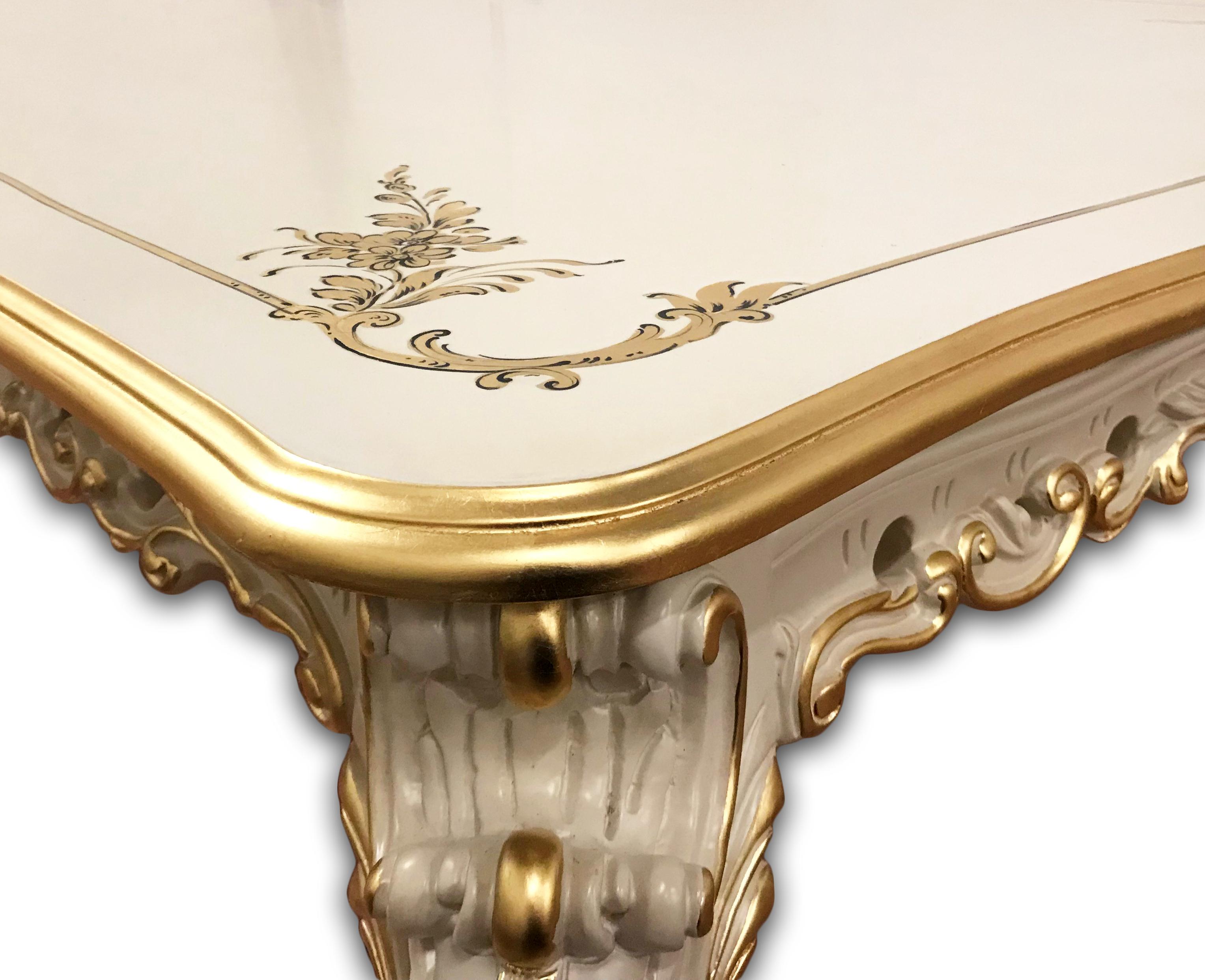 There are many details that make this Venetian style dining table very luxurious. From solid wood, soft ivory color, to cabriole legs with intricately handcrafted wood carvings on the apron to a sophisticated golden accent finishing around the trim,