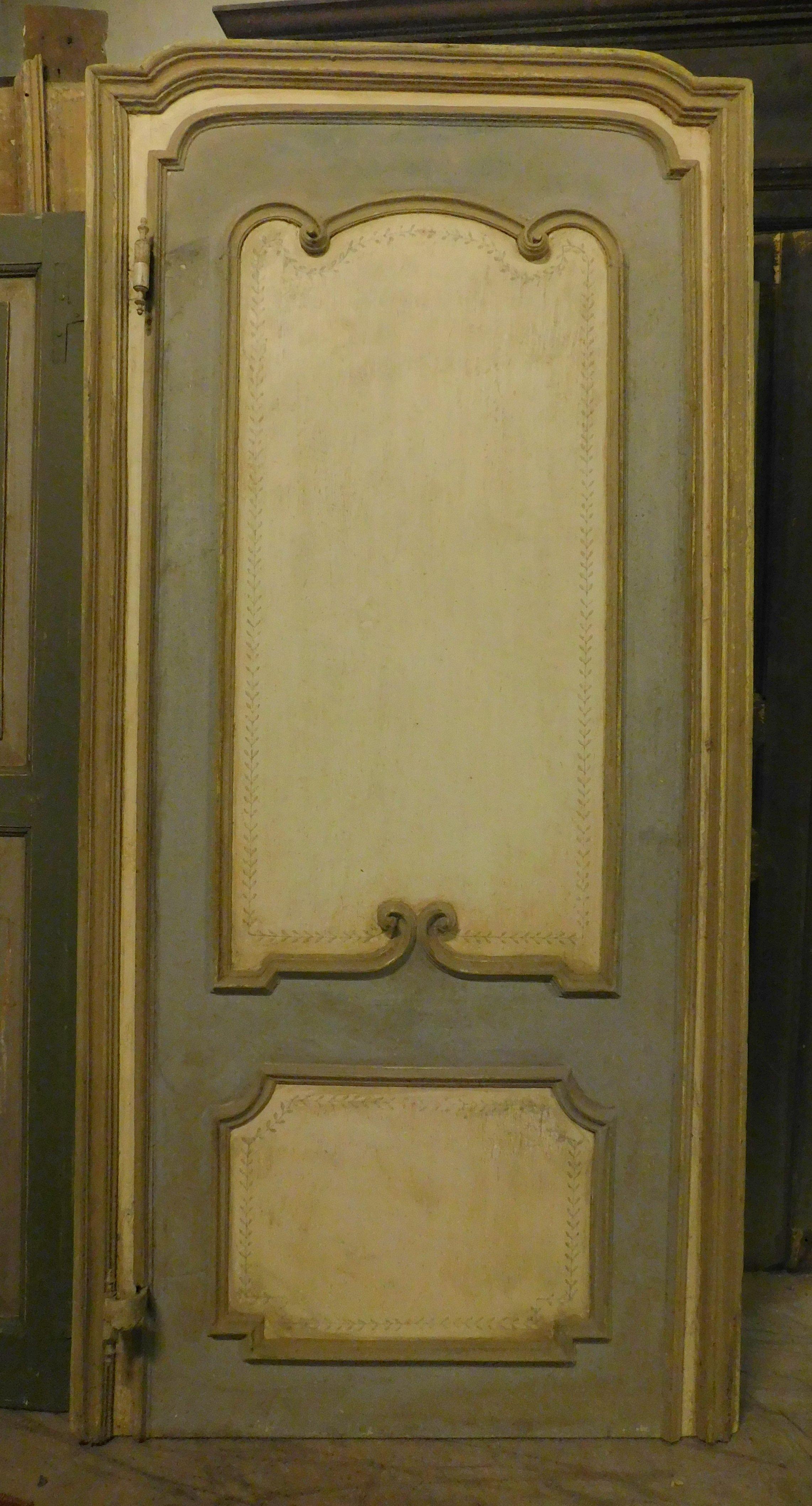 Ancient Baroque door, hand-sculpted with mouldings in relief in curls, typical of the period and lacquered with 3 colours, has an arched shape and is complete with the original frame with gooseneck irons (crooked opening and self-closing), built in
