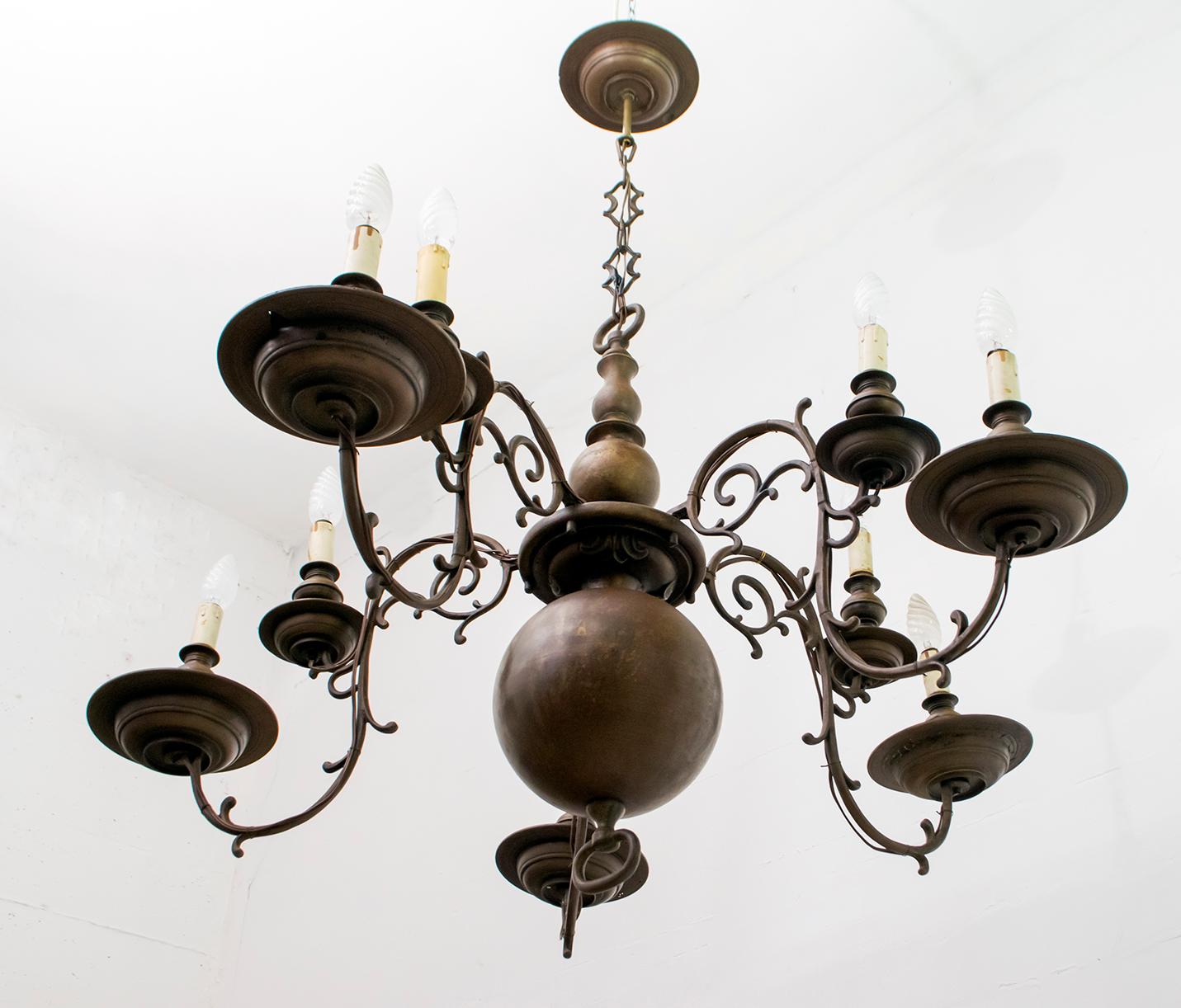 Dieser Kronleuchter aus Bronze von 1700, der in der Antike mit Kerzen betrieben wurde (siehe Zugstange unter der Kugel), wurde später modifiziert und mit E14-Glühbirnen und originalen Holzfassungen von Anfang 1900 elektrisch gemacht.
Der