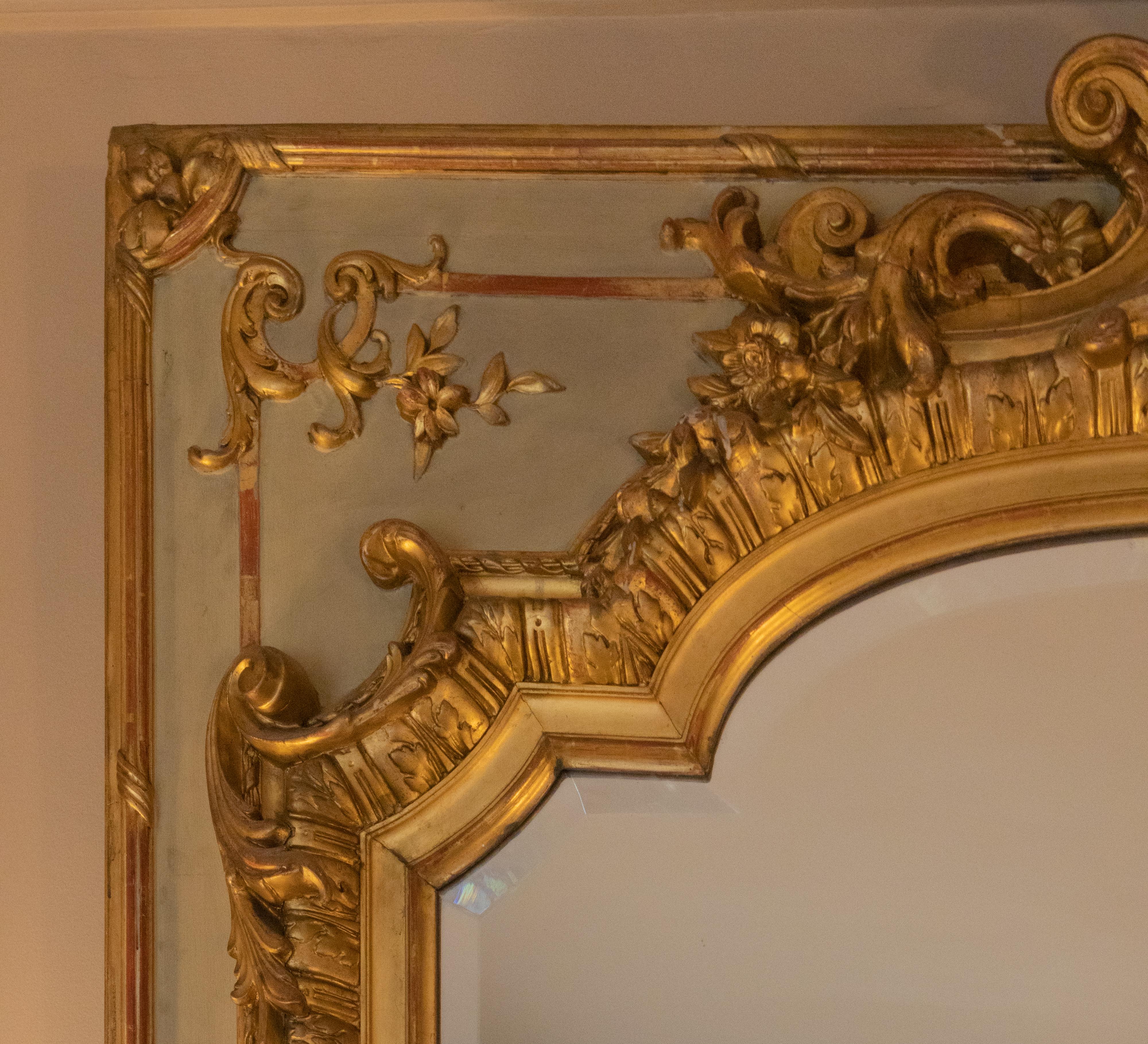 A beautiful Tremeau 19th Century mirror painted and with gilded parceling, rectangular mirror in a greenish-gray rectangular frame and stucco decoration in gold leaf, rococo motifs and reliefs such as rolled acanthus leaves, foliage and rope