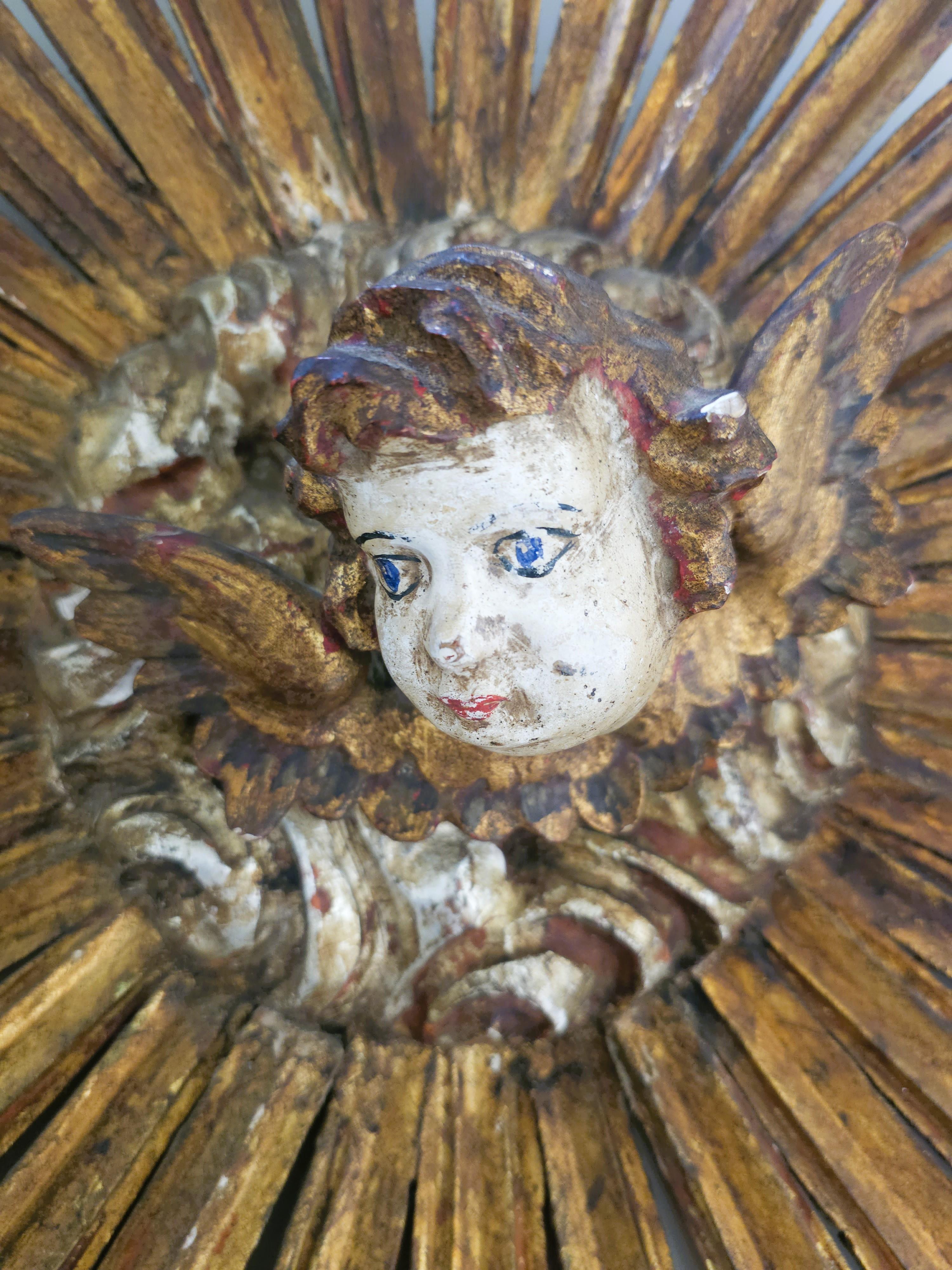 Precioso y detallado. Exquisita y rara escultura mural barroca del siglo XVIII, probablemente originaria del sur de Europa -España o Italia- hacia 1680-1750. Tallada a mano en madera con acabado original dorado y policromado, presenta una cabeza