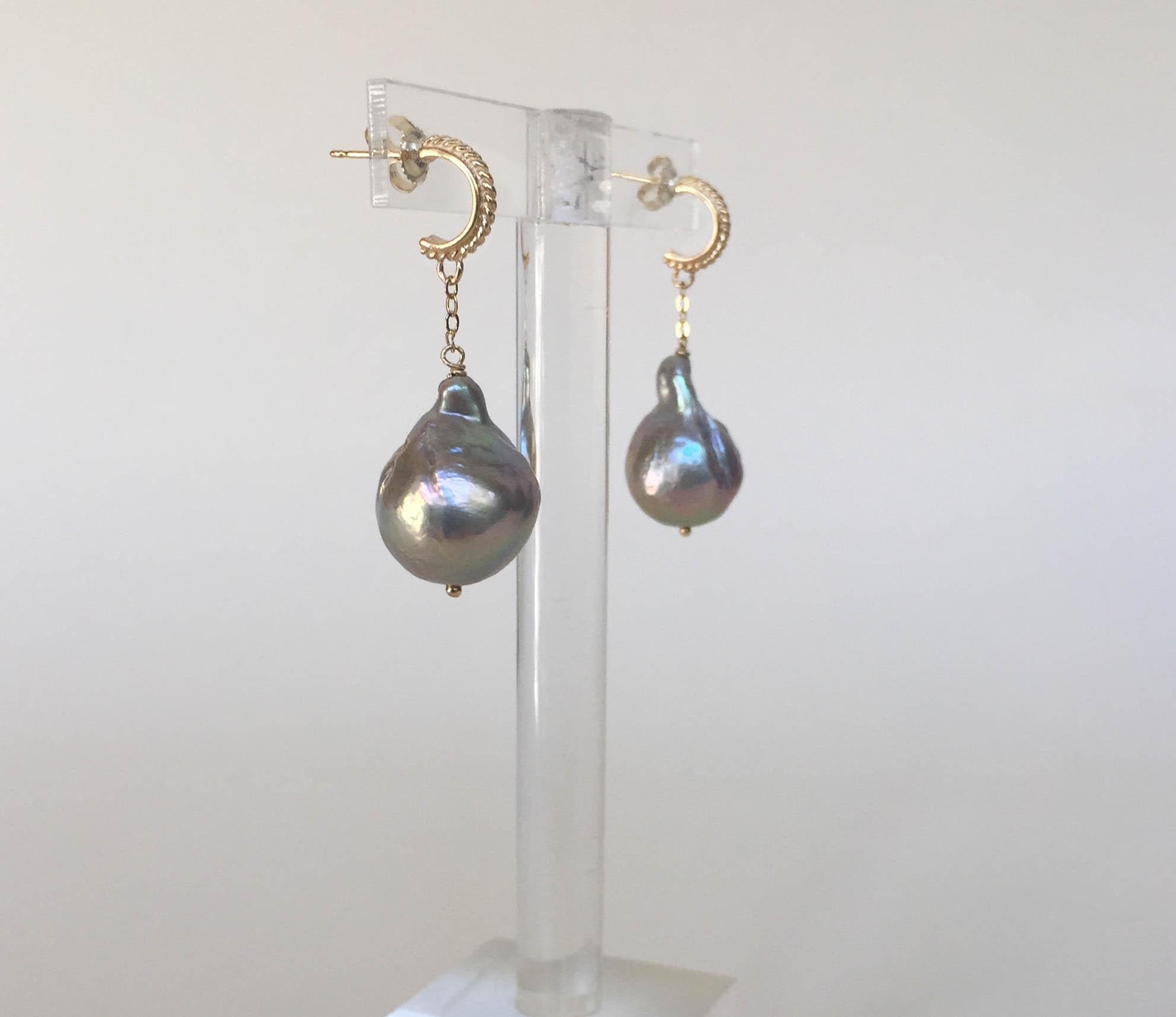 These small yet dramatic baroque gray pearl dangle earrings with 14k yellow gold stud and chain are striking with the gray and yellow gold color combination. The pearls dangle elegantly from a 14k yellow chain and detailed stud. At 1.2 inches these