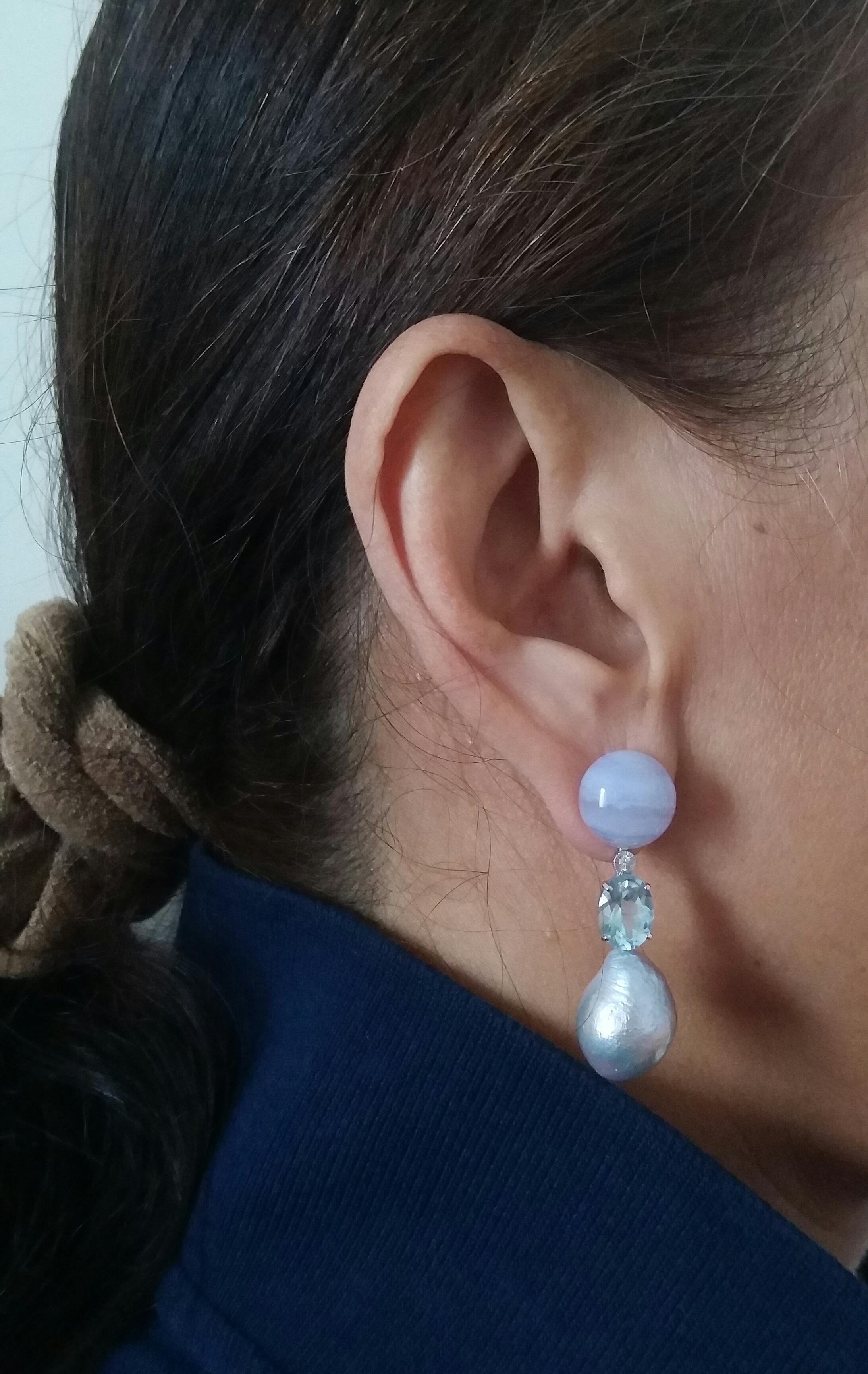 2 round buttons of 12 mm diameter support 2 faceted blue topaz measuring 9x7 mm, 2 small full cut diamonds and finally 2 baroque pearls of natural grey diameter 12 mm.
n 1978 our workshop started in Italy to make simple-chic Art Deco style