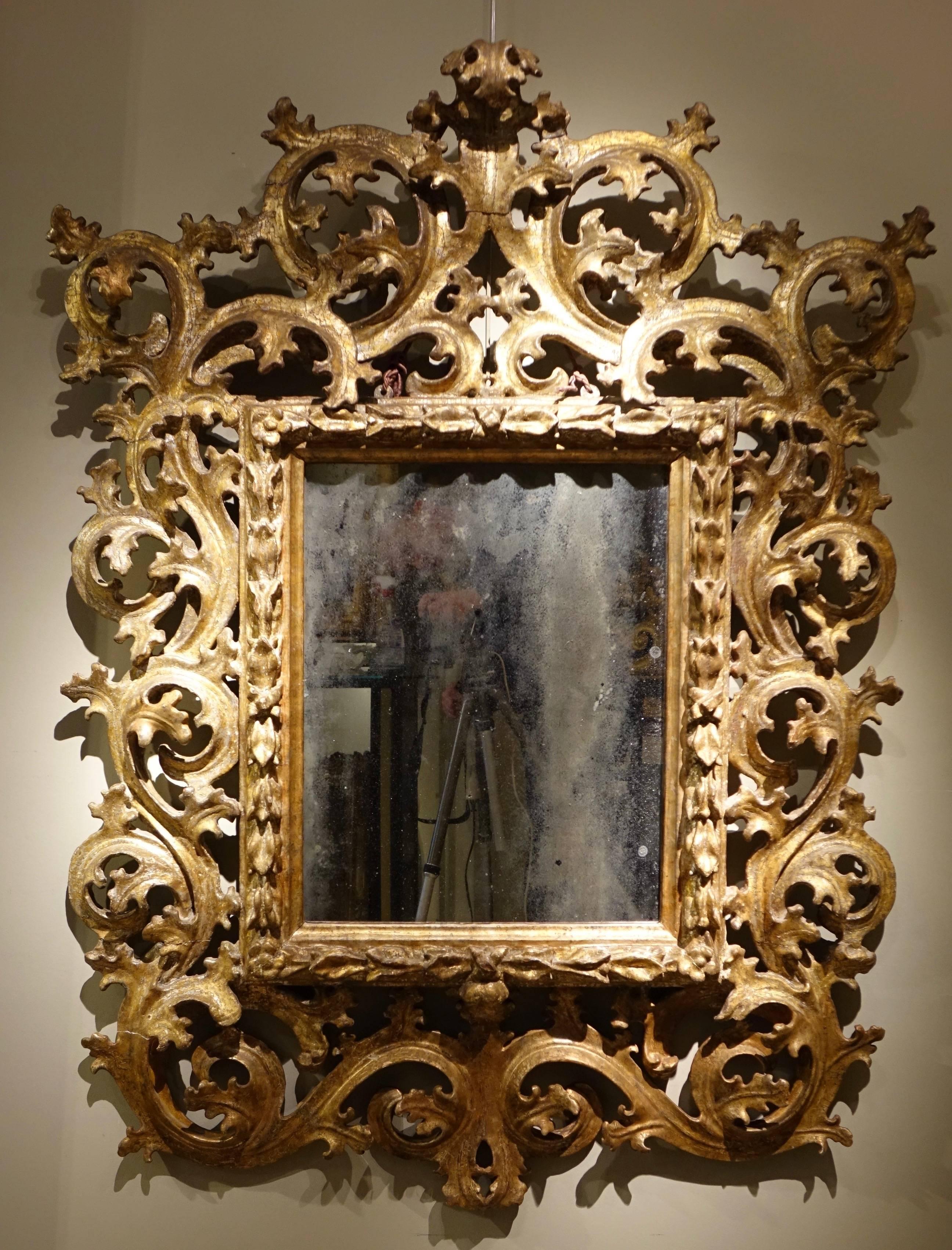 Baroque mirror richly carved with foliage scrolls, mecca giltwood 
Mercury center mirror 
Naples or Kingdom of Sicily, late 17th-early 18th century.
Wear and tear, restorations, back not parqueted.