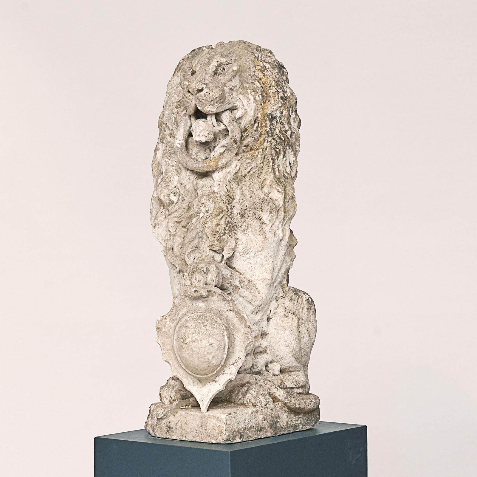 French carved seated lion with a ring in his mouth.
Holding a crest.

Carved in French limestone, c 1700's.

Provenance: The Danish author Karen Branson 1875-1936, One of two carved loins that flanked the main entrance the her house called