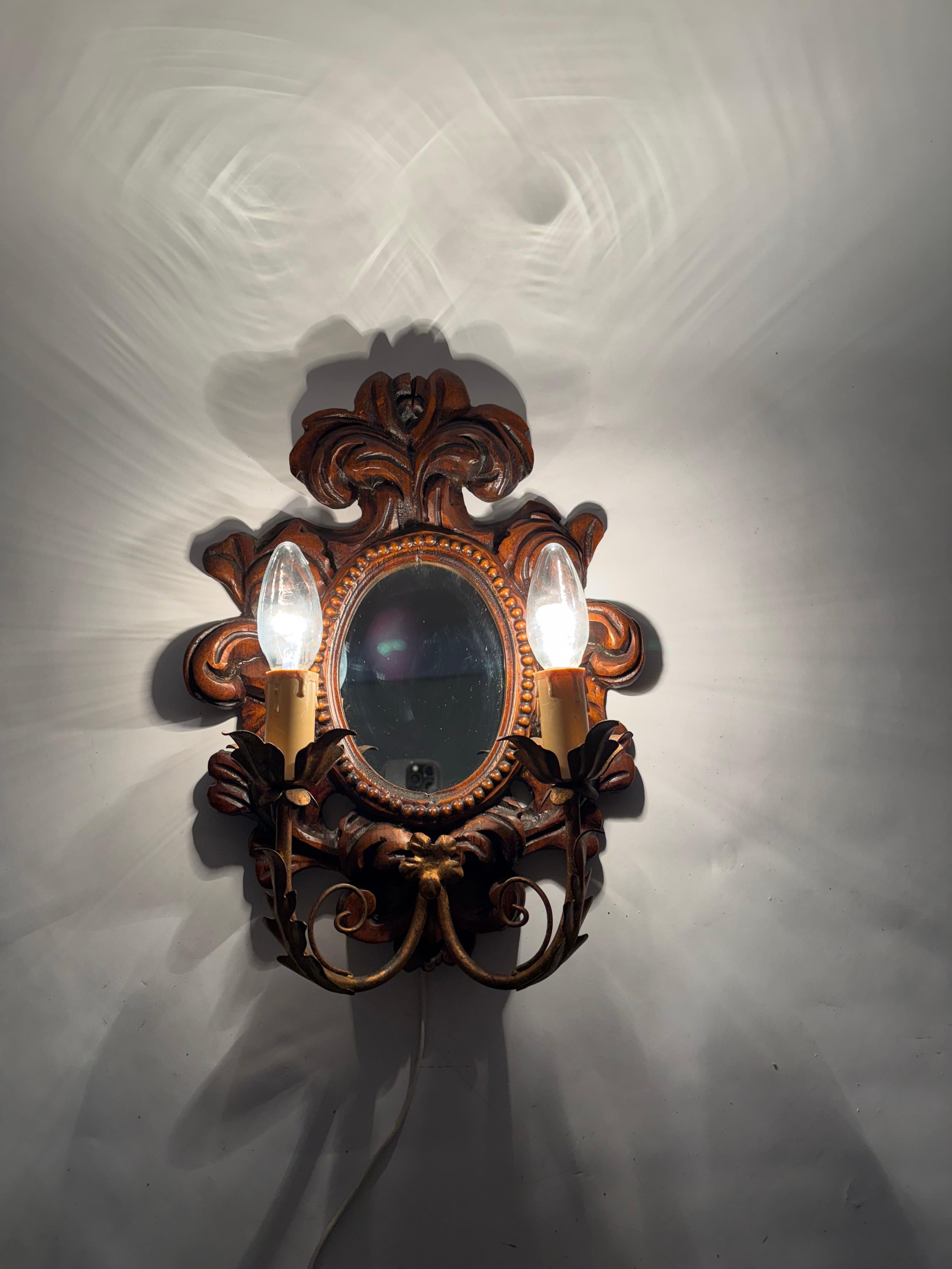 Esta impresionante lámpara de pared, elaborada en el elegante estilo del barroco de lujo con espejo, fue hecha con cariño por un hábil artesano en la década de 1960. ¡Es una auténtica joya! La lámpara fue cuidadosamente tallada a mano por un