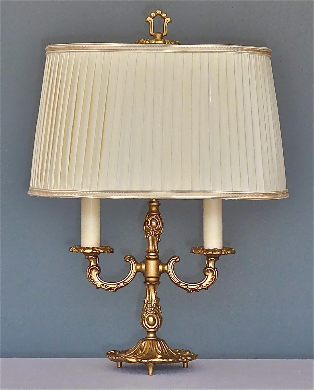 Baroque style patinated brass table lamp with floral leaf details, Germany around 1950s to 1960s. The high quality midcentury table lamp is 50 cm / 19.69 inches tall 23 cm / 9.06 inches wide and has a width of 12 cm / 4.72 inches at the base. It has