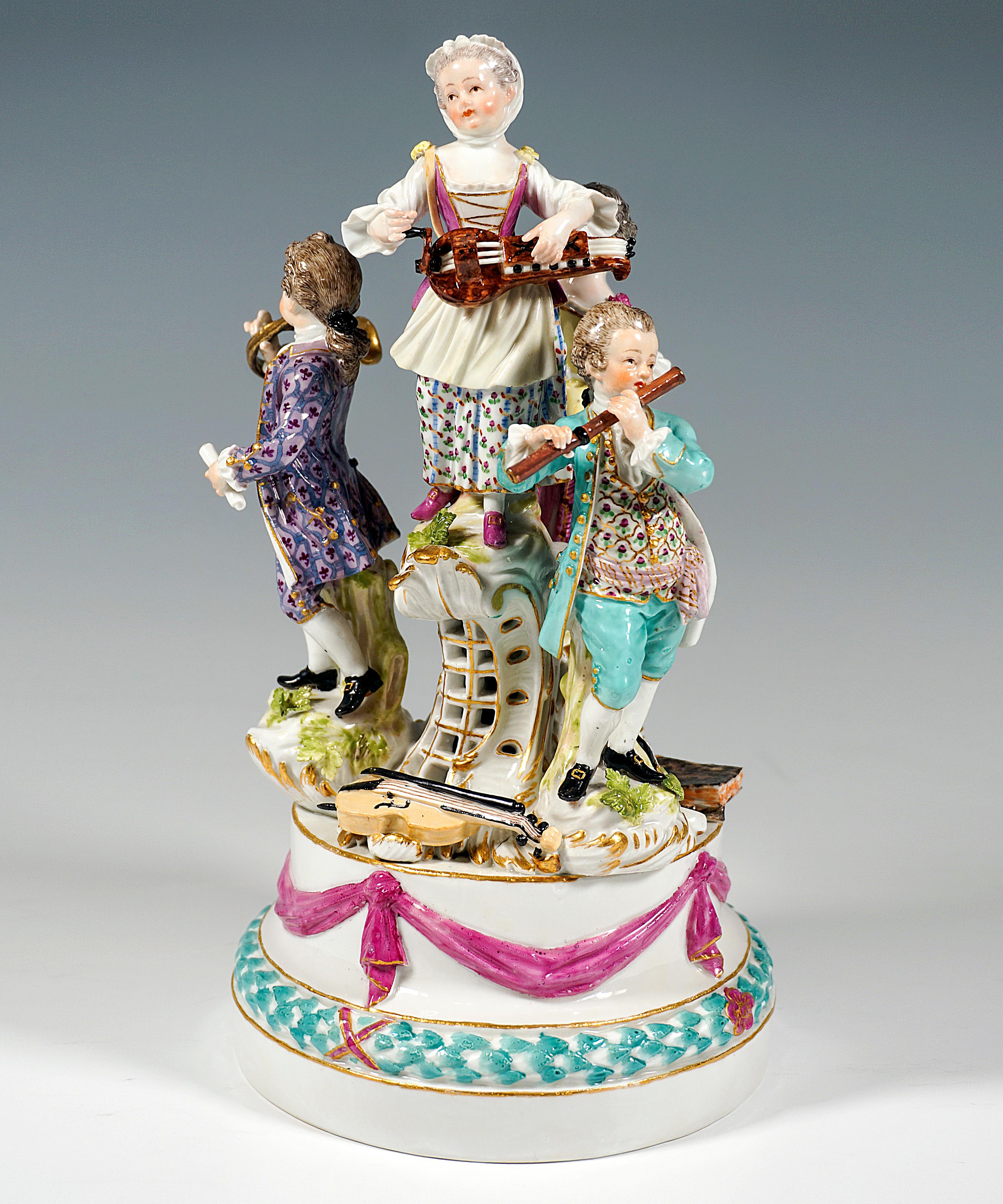 Excellent Meissen piece from the time the model was created:
Four children in festive rural rococo clothing on a high, tiered round base, decorated with a leaf wreath and ribbon festoon with gold decoration, on the base further pedestals of