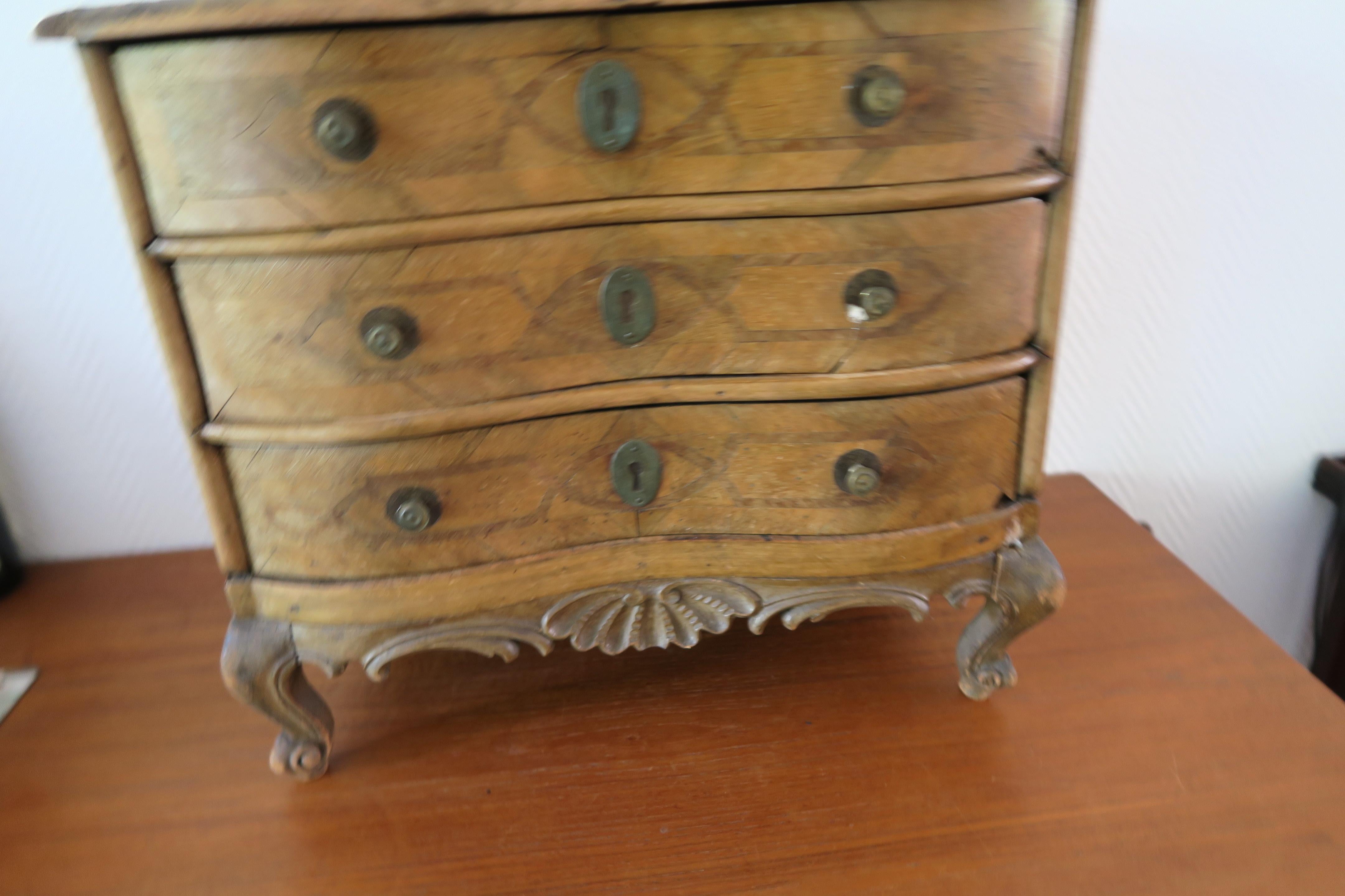 Cassettiera barocca in miniatura del XIX secolo
Bellissimi dettagli intagliati
L'impiallacciatura della parte superiore è in parte scomparsa, il che espone i disegni.