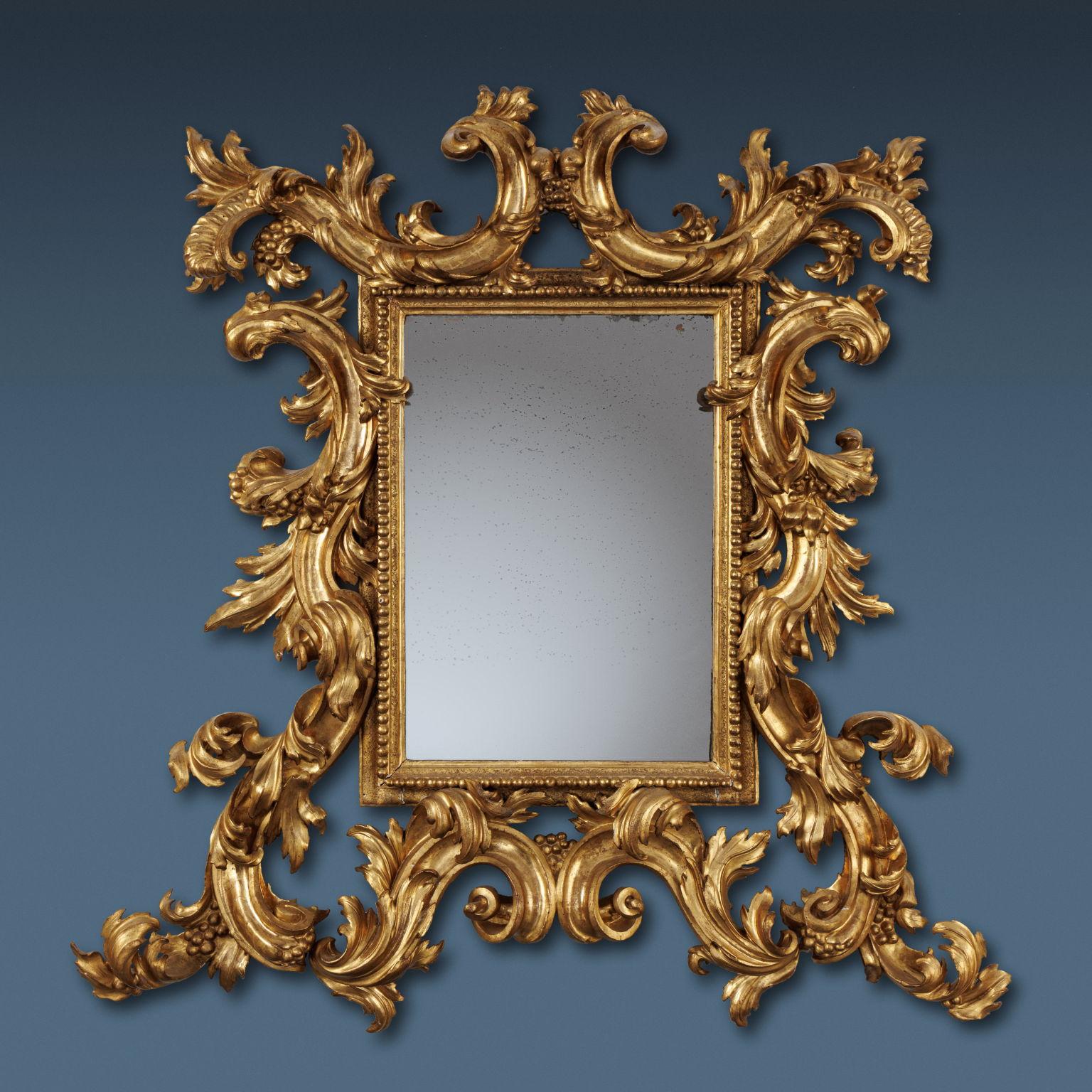Large frame consisting of a carved ledge with successive pods motif; from this branch off fleshy and voluminous scrolls ending in a curl, decorated with leafy, floral and small fruit motifs. Entirely gilded with leaf; the mirror is mercury.
In the