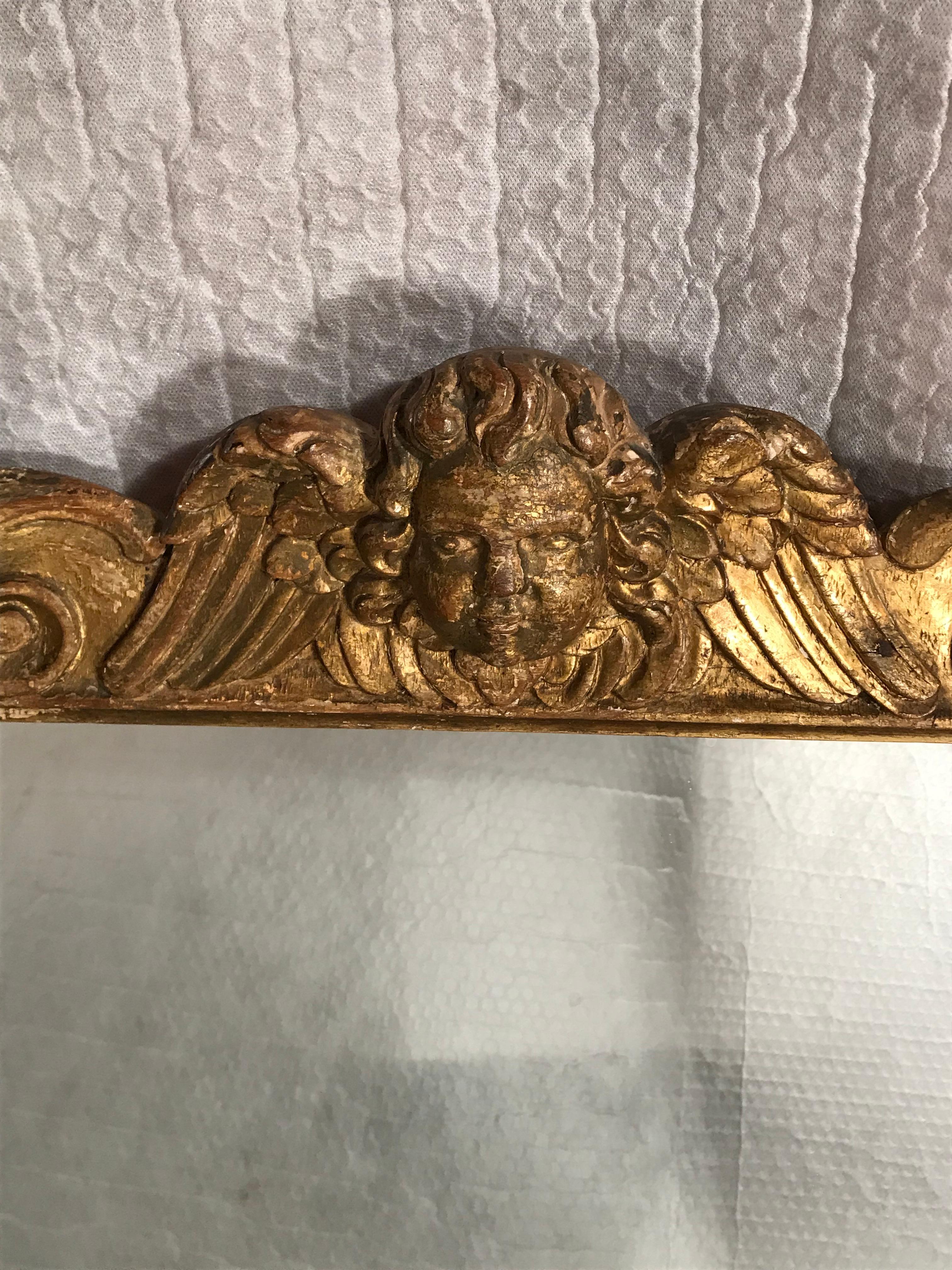 Unique Baroque mirror, France, 1700-1720. Rectangular mirror with beautifully wood carved frame decorated with acanthus leave decor, crowned by a cherub head. In good, vintage condition. The mirror glass has been replaced. 