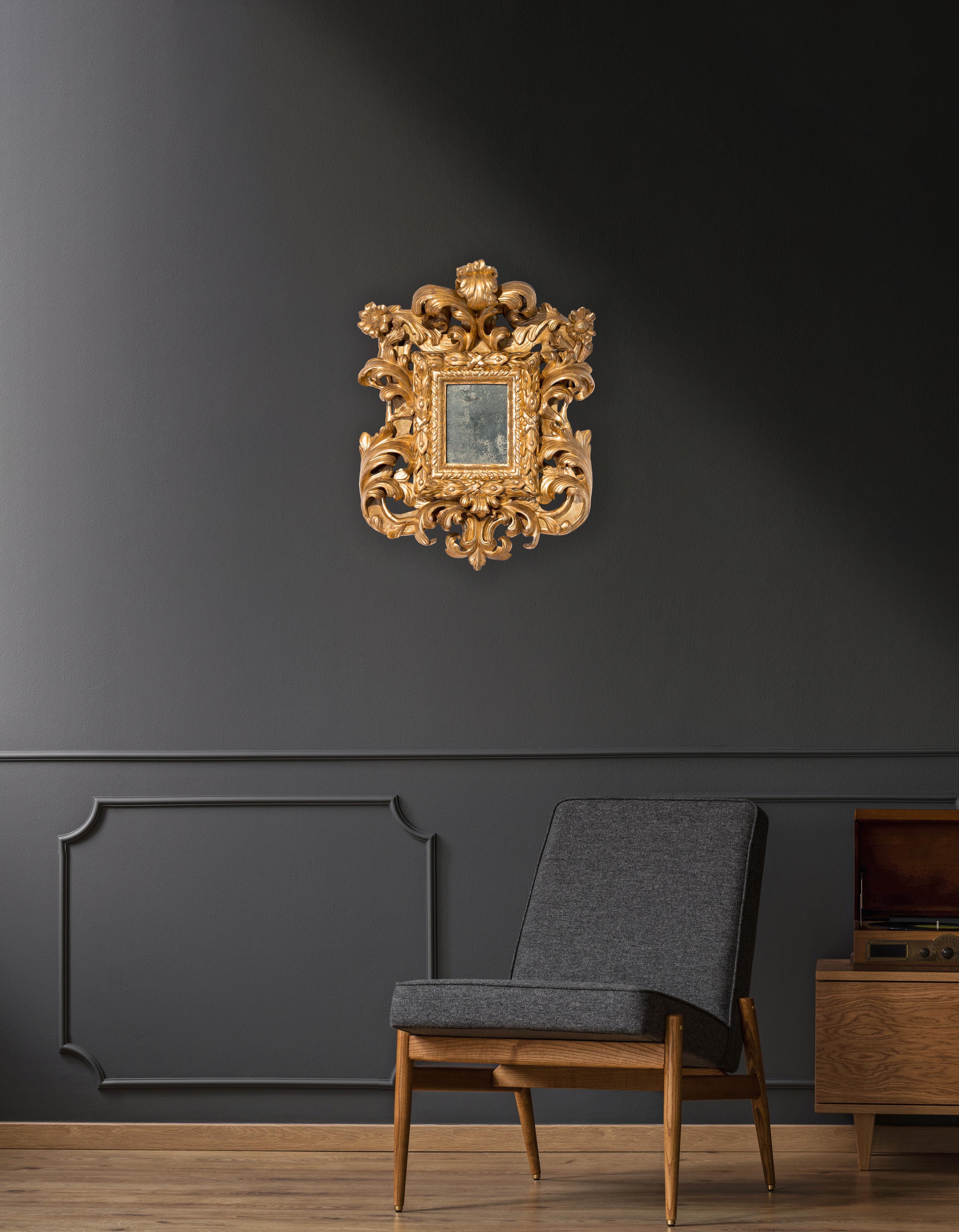 Magnifique miroir en bois doré, Rome, période baroque. Bord intérieur sculpté d'une guirlande de myrte, de palmettes et d'un ruban enroulé. Frises et grandes feuilles d'acanthe torsadées, volutes et fleurs aux angles supérieurs.
Période : Louis XIV