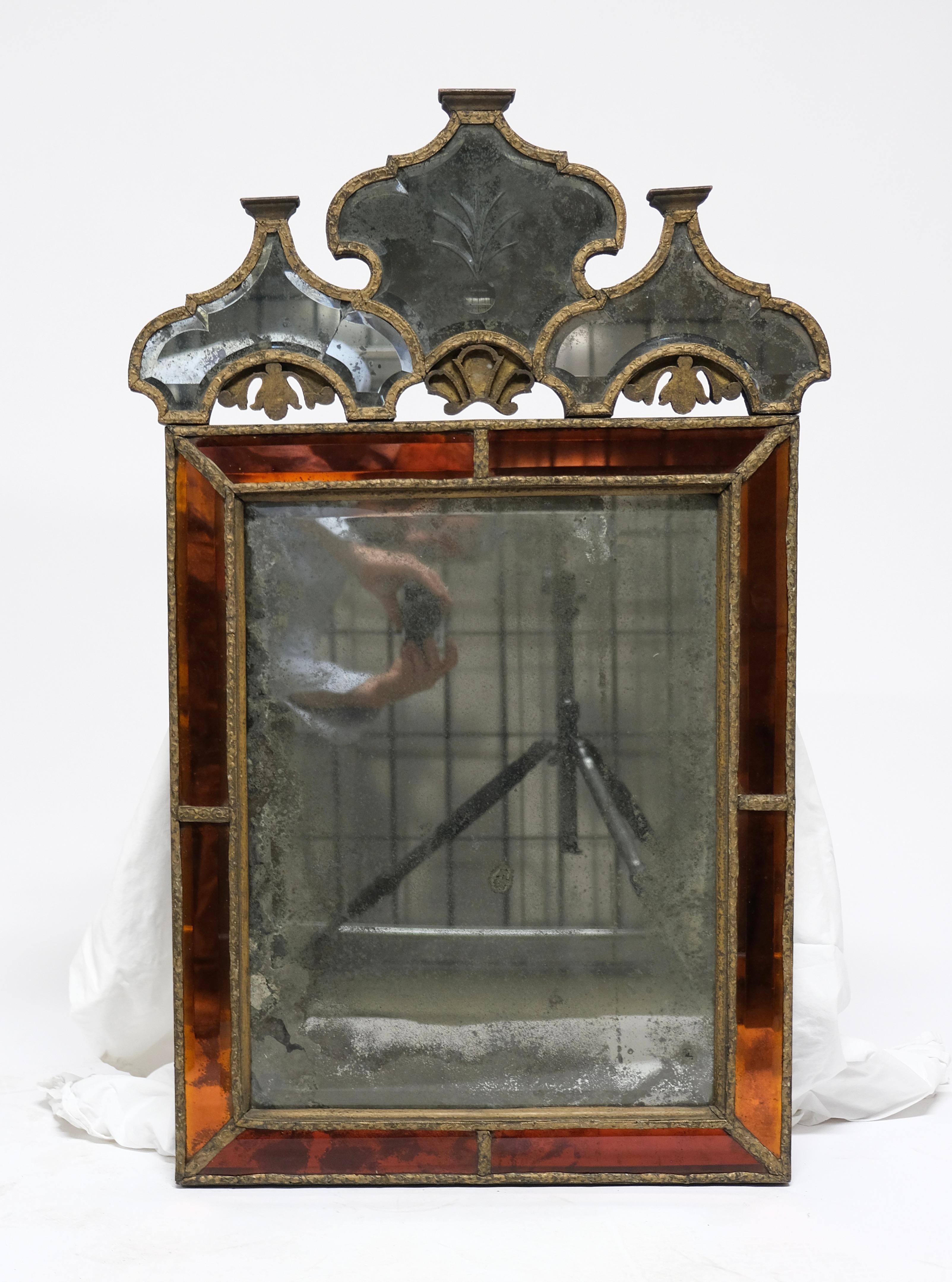 A untouched baroque-mirror made around year 1700. It still has its original mirror glass that is exclusive and rare with its cut edges. Around the mirror glass is a frame of amber coloured glass which is also is extremely unusual. The patina is