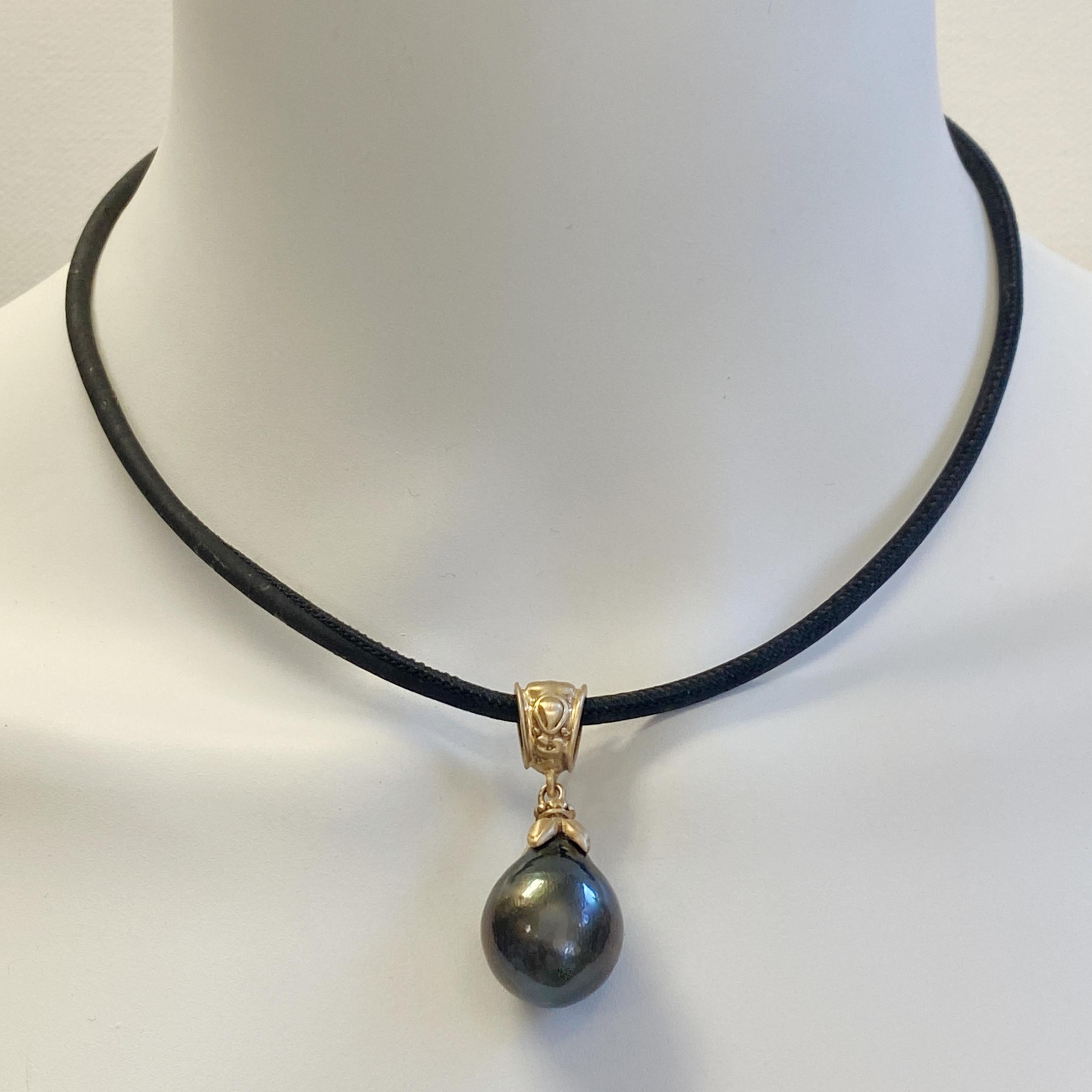 This enormous (over 15mm), dark and sultry, richly hued black pearl is set in a Byzantine-flavored, satiny 18 karat yellow gold pedant handmade in our shop by Eytan Brandes.    

Our pearl dealer, who specializes in jumbo South Sea white and black