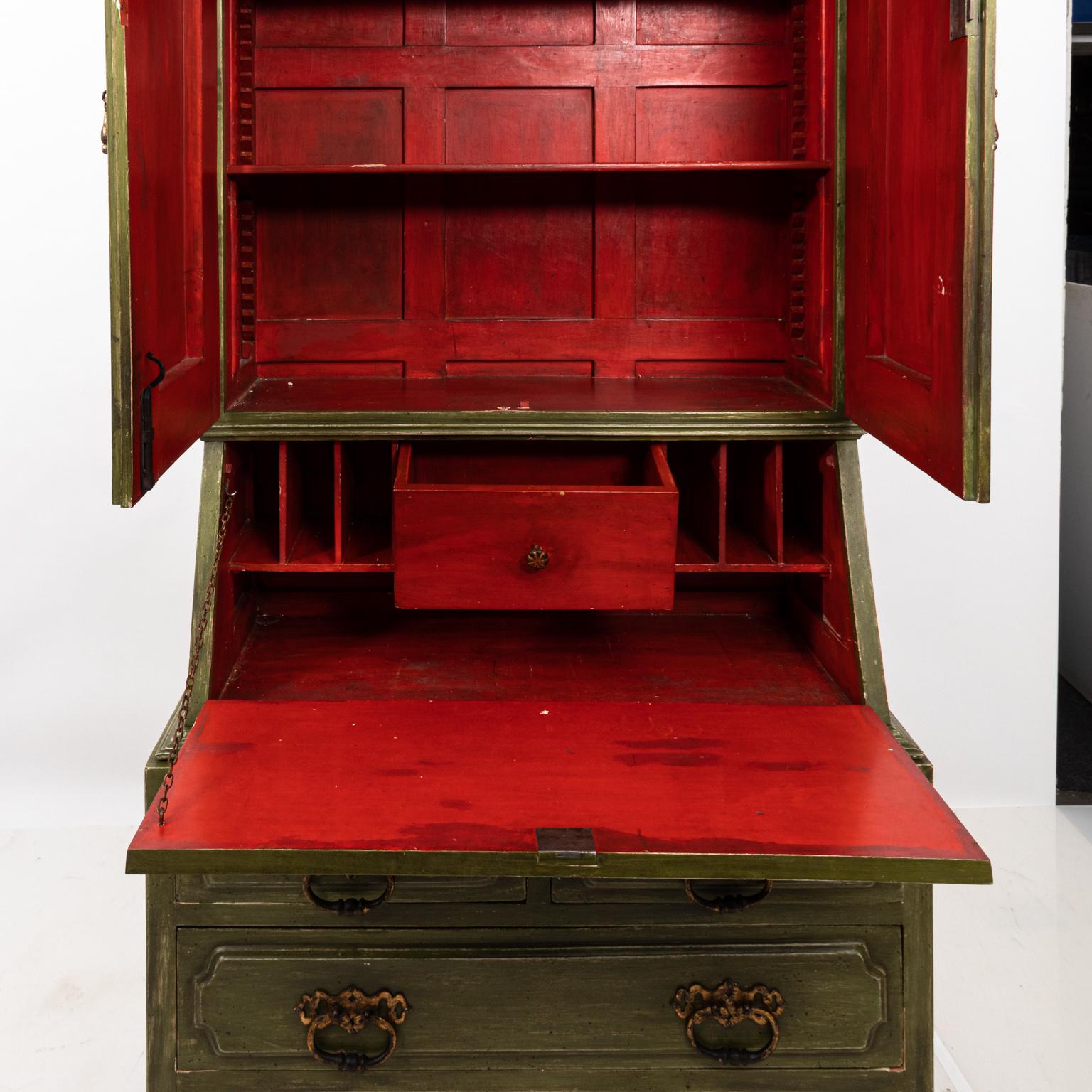 Baroque painted secretary desk with metal hardware and large turned finials. The piece also features a two-door cabinet painted with red interior and adjustable shelves. The base includes a bottom set of two long drawers and two small drawers.