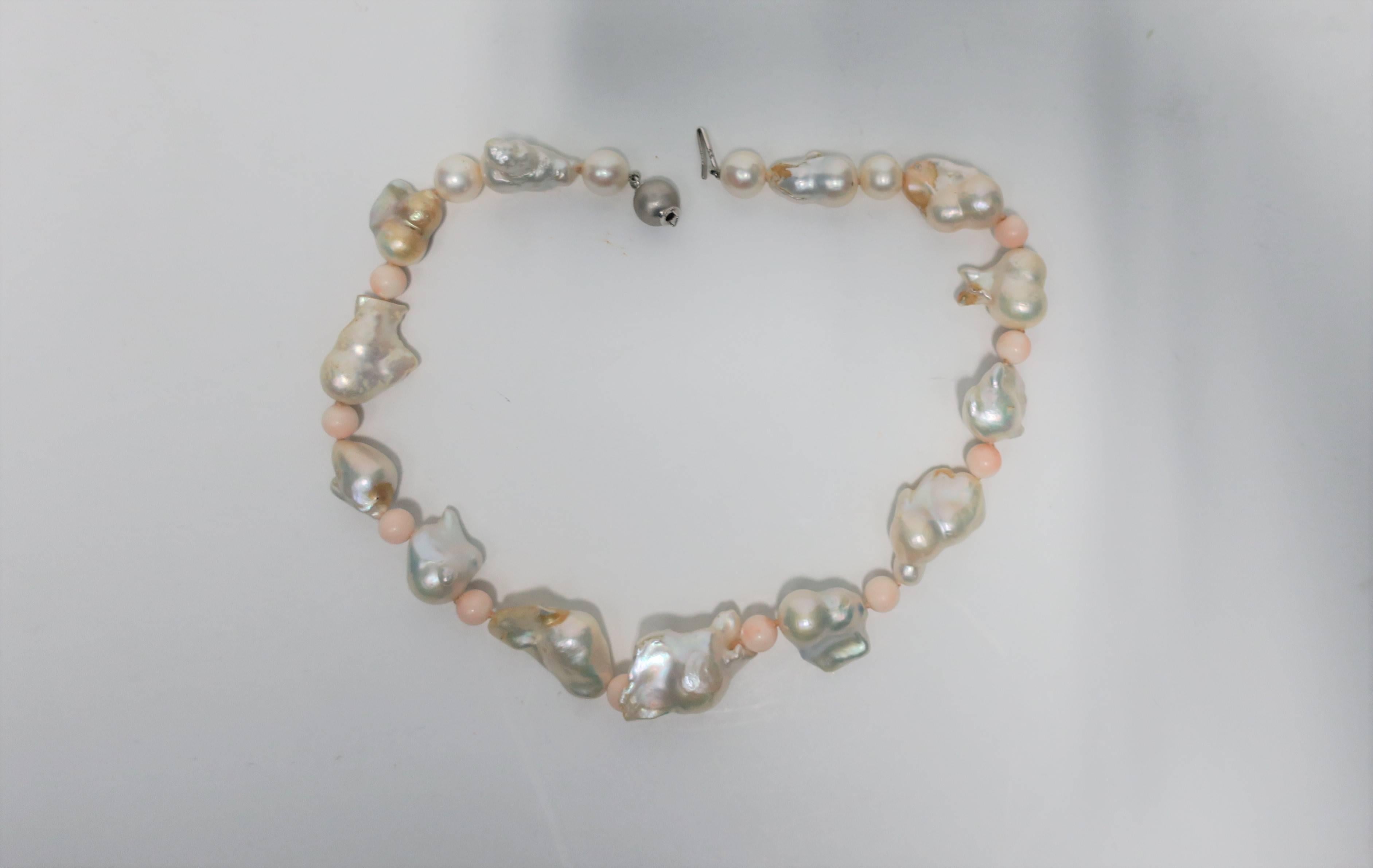 A very beautiful necklace of large baroque white freshwater pearls, light pink coral beads, cultured pearls and 18-karat white gold bead and clasp. White gold bead/clasp (looks like a grey pearl) is sandwiched by two white cultured pearls (see