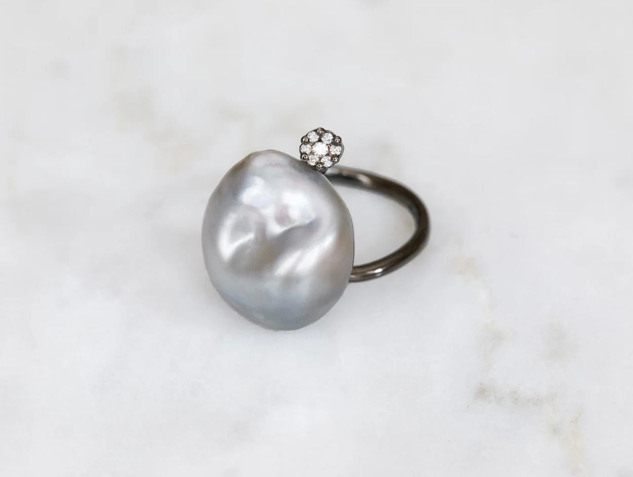 Ein aufsehenerregender, moderner Ring mit Süßwasser-Barockperlen und einem Diamant im Brillantschliff, gefasst in 18 Karat Weißgold. Gewicht des Diamanten 0,10cts. 

14mm mit 18kt Weißgold und 0,10cts Diamanten