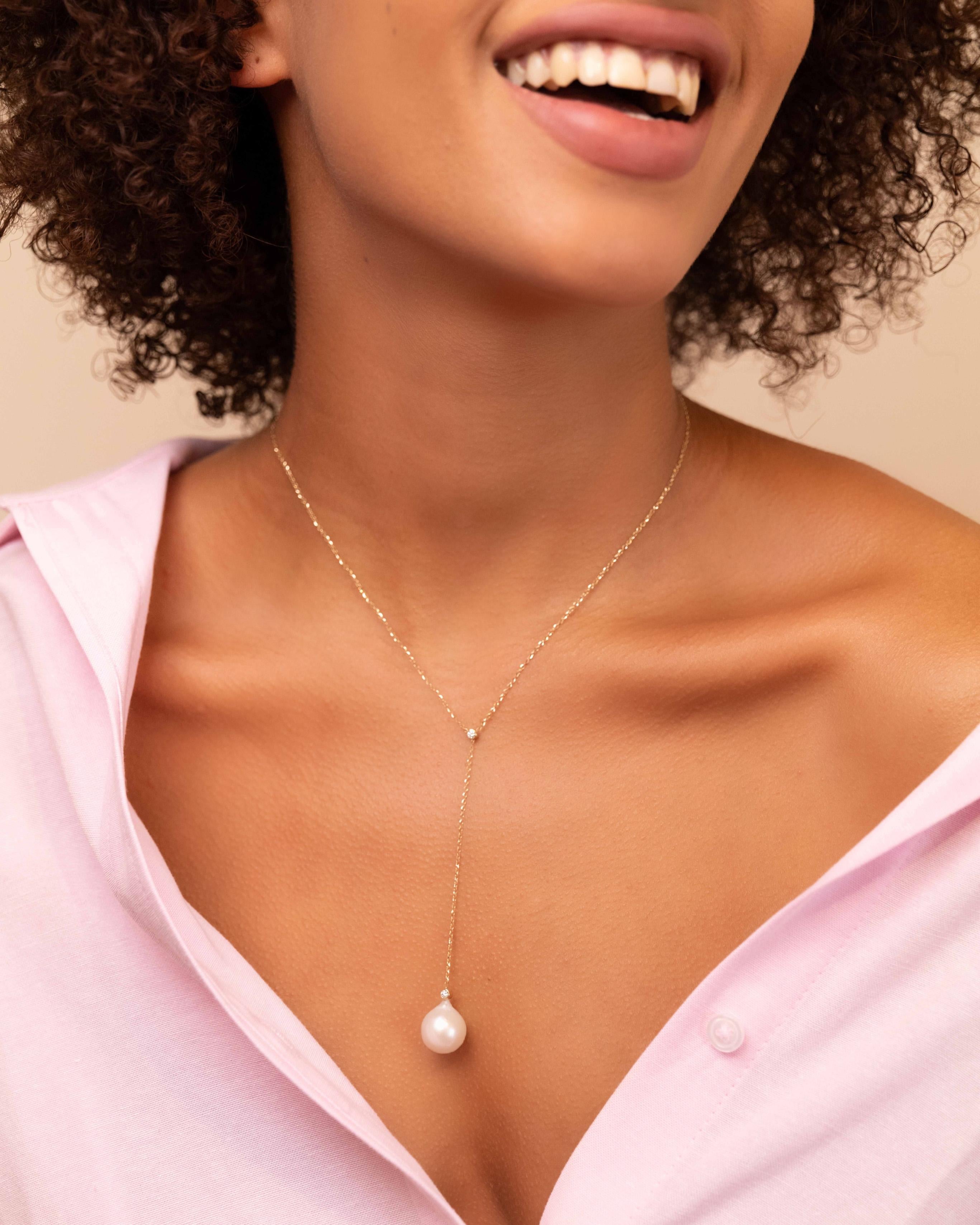 Our lariat necklace features a baroque drop shaped pearl suspended from a sparkly chain and accentuated by two glimmering diamonds. The simplicity in its silhouette combined with the high-quality materials used, make this the ultimate day to night