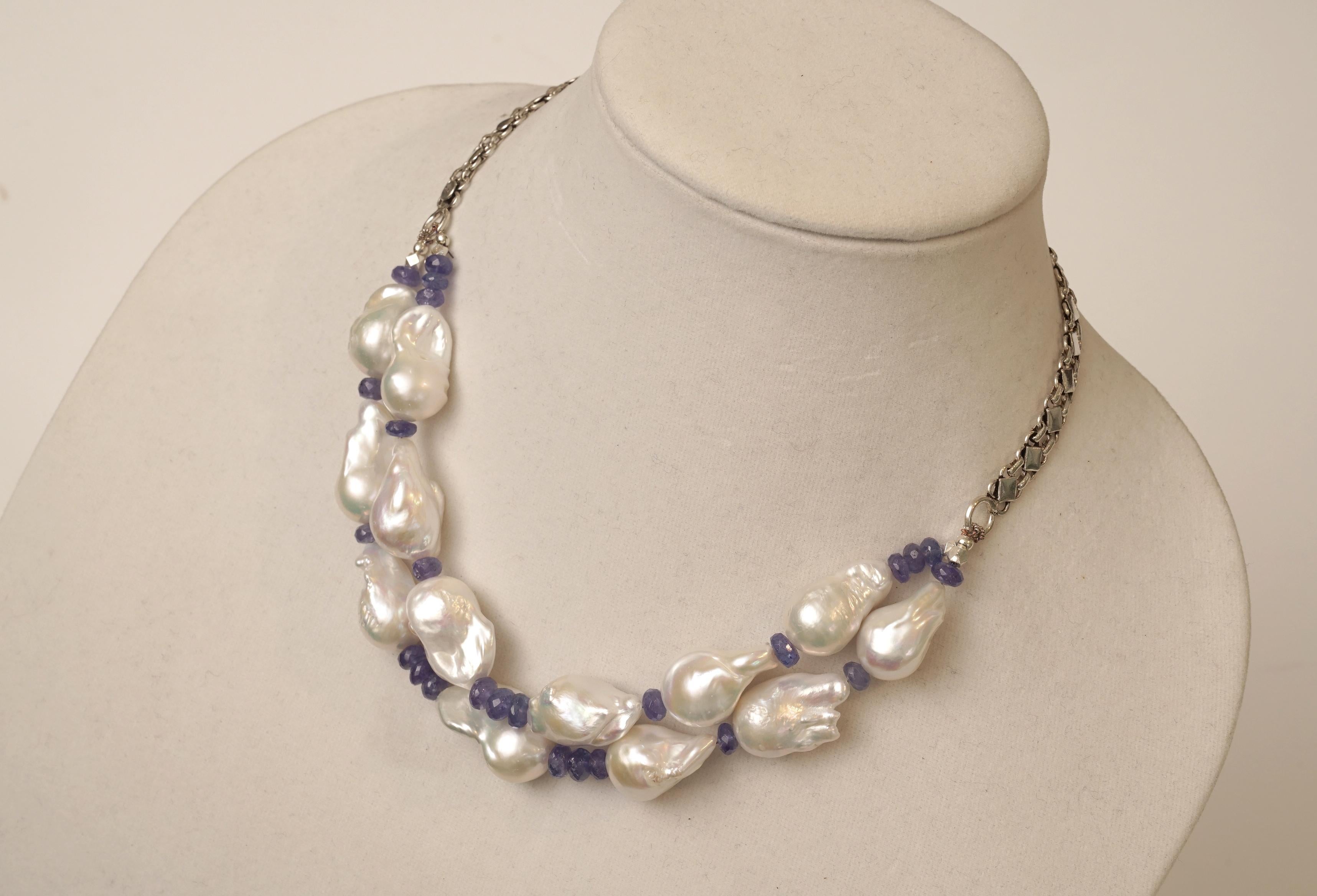 A double line of lovely baroque white pearls with excellent luster strung with faceted Tanzanite beads and sterling silver along the back.  By Deborah Lockhart Phillips.  The length can be adjusted at the back and length runs from 18 - 20 inches.
