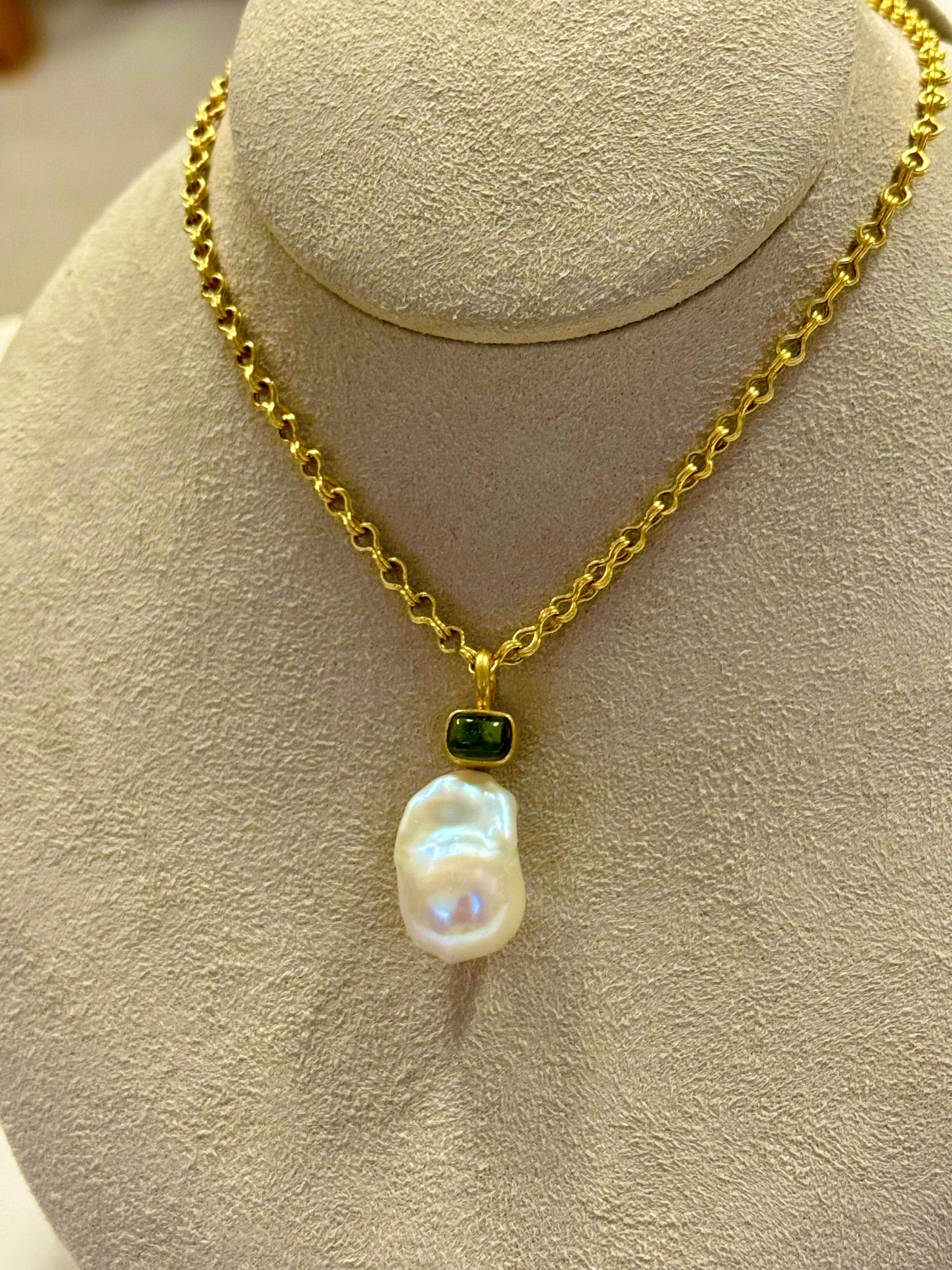 Grazioso ciondolo con una tormalina verde cabochon e una grande perla barocca incastonata in oro 22 carati.
Il pezzo è interamente realizzato a mano nello studio dell'artista a New York.
L'altro ciondolo con la tormalina rosa è stato venduto.
La