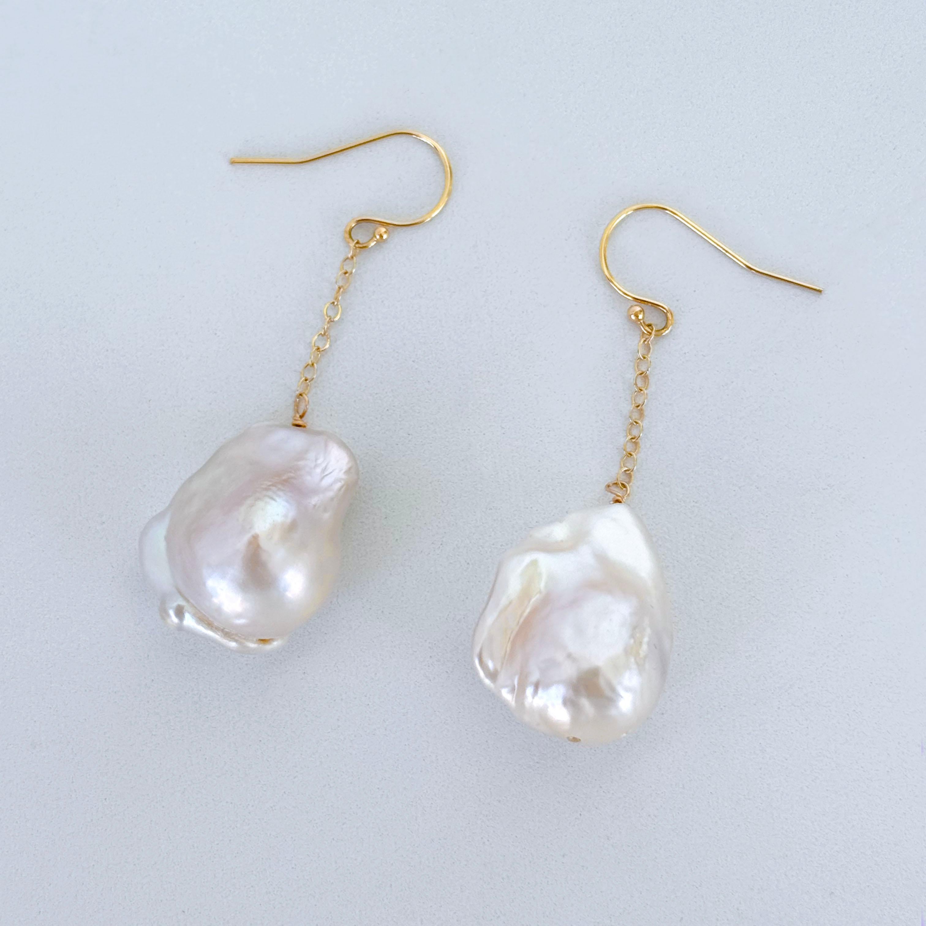 Two gorgeous Baroque Pearls displaying a beautiful iridescent luster hang from Solid 14k Yellow Gold Chain that attaches to Solid 14k Yellow Gold Hooks.

This pair can easily be worn up or down for a casual or formal outfit. Measuring 2 inches long,