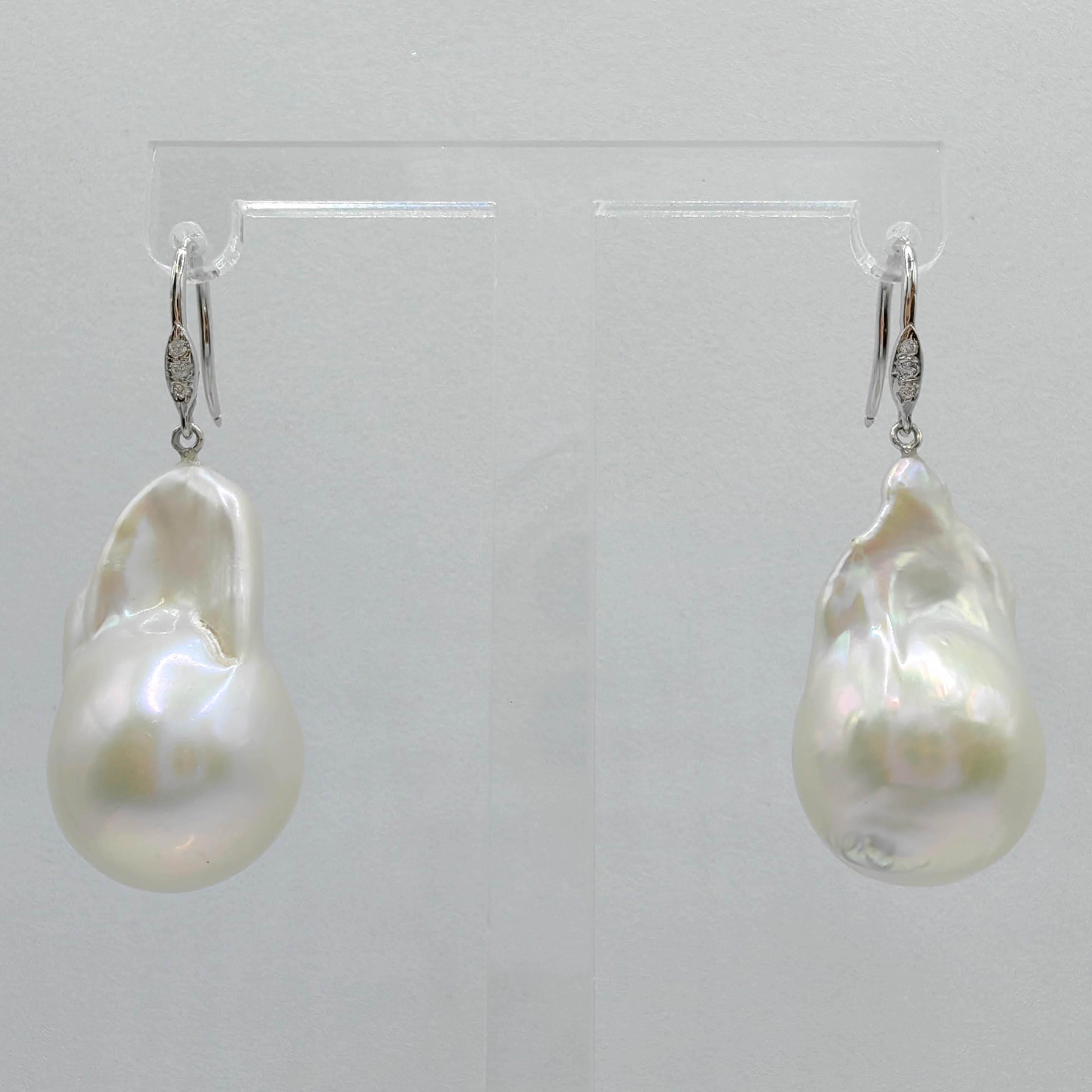 Indulge in the enchanting elegance of our Baroque Pearl Diamond Dangling Drop Earrings with 18K White Gold French Hooks. Featuring two captivating Freshwater Cultured Baroque Pearls, weighing 30.66 and 28.75 carats respectively, these earrings exude