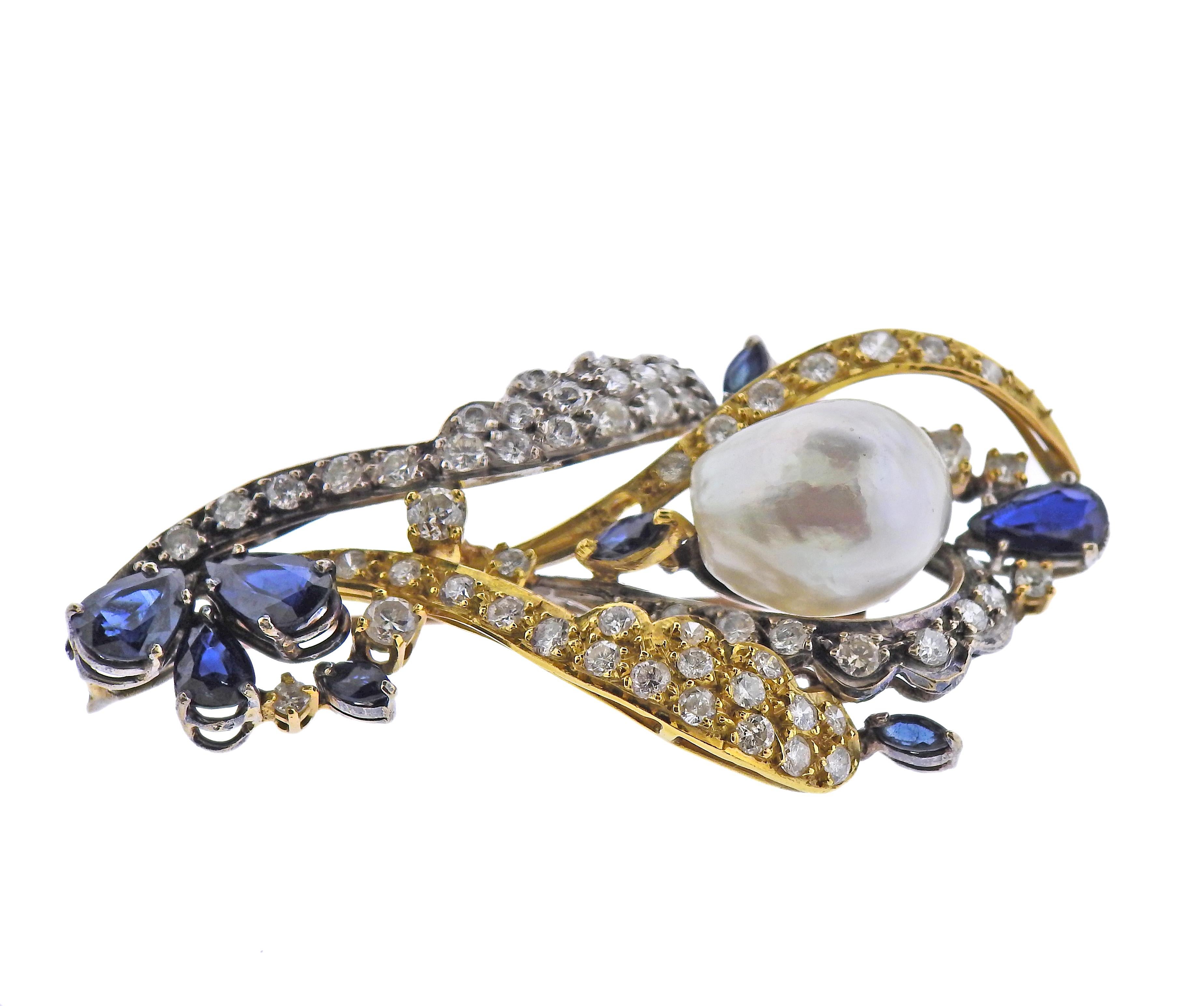 14k white and yellow gold brooch/pendant, featuring one 14.9 x 12.2mm Baroque pearl, surrounded with blue sapphires and approx. 2.20ctw in diamonds. Brooch is 56mm x 33mm. Weight - 15.9 grams.
