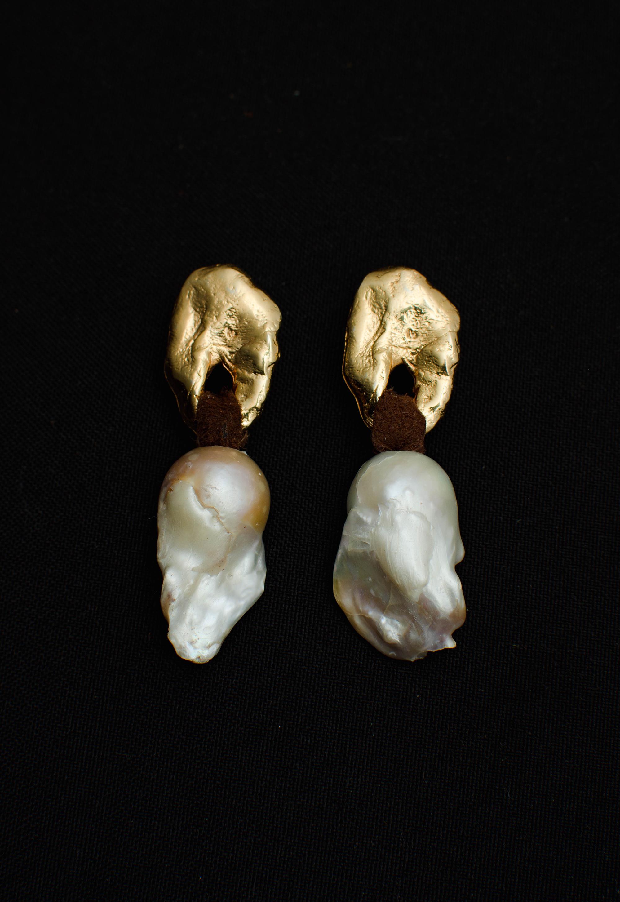 These pieces were designed, hand-carved, and then cast from our workshop in Uruguay. Silver used in this manufacturing process is fully recycled       

Details
Baroque Pearl / Leather / 24 k Gold Plated Sterling Silver 
4 cm long 
Free Shipping