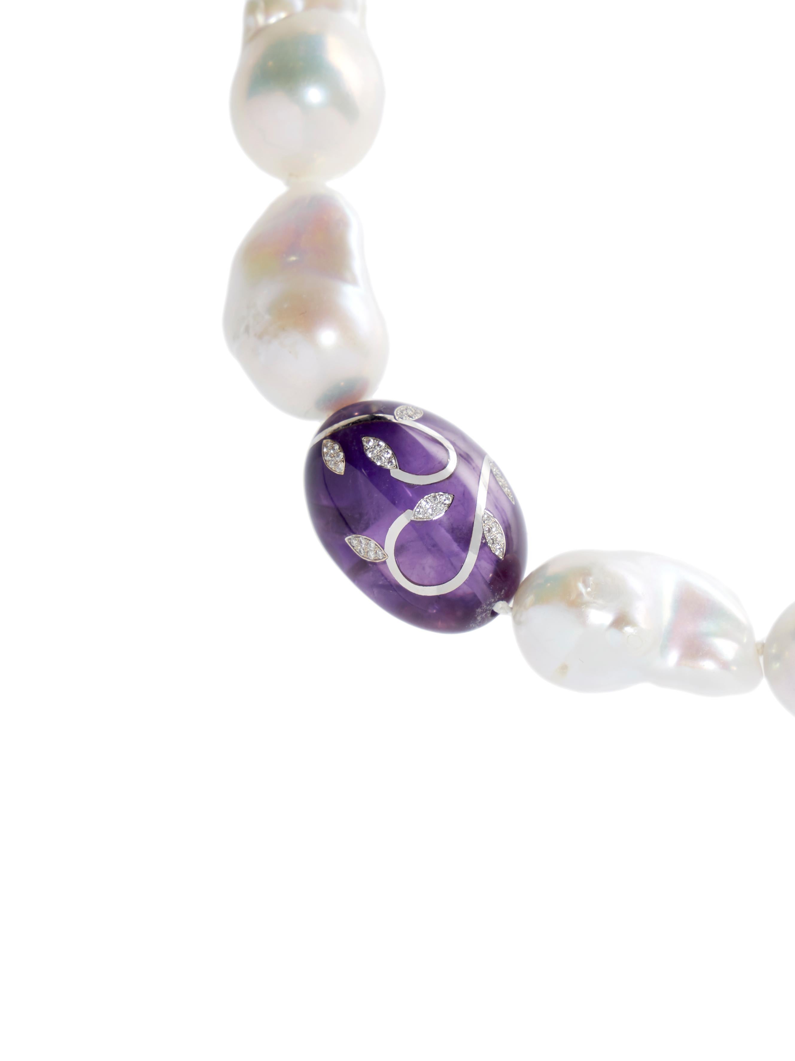 Baroque pearl necklace with a beautiful quality amethyst bead with floral decoration executed with high carat white gold inlay and set with faceted diamonds.

These baroque pearls are of a very good quality with a beautiful luster and are averaging