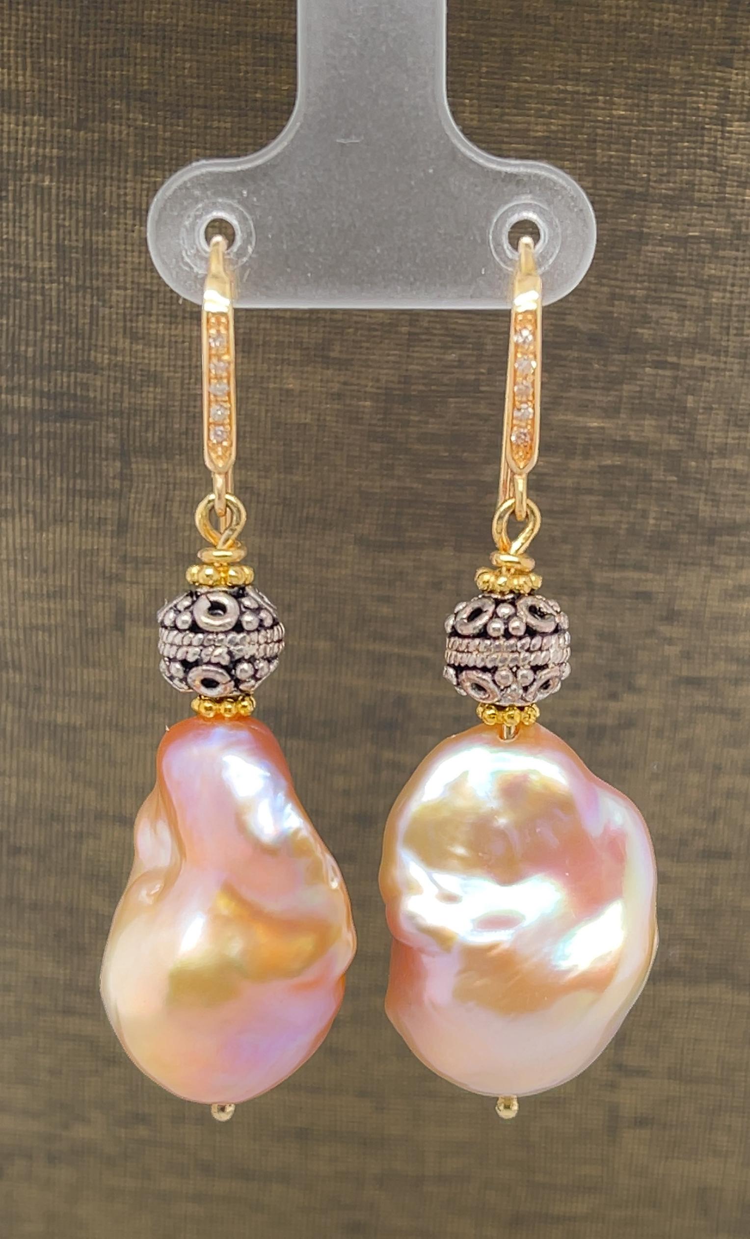 These pretty drop earrings feature large, freshwater baroque pearls with gorgeous silvery pink color and excellent luster. They are set in 18k yellow gold and accented with decorative sterling silver beads for a lovely combination of color and