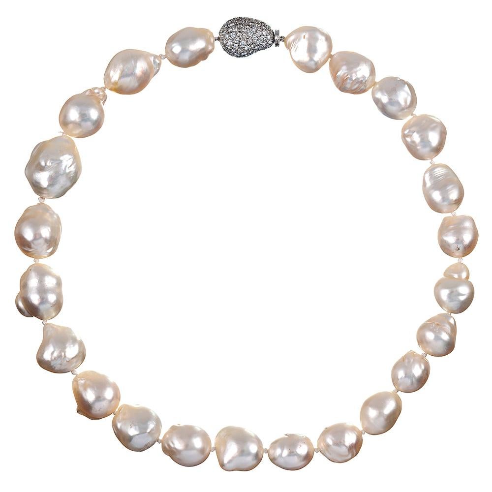 A marvelous creation, originally sold for $98,000 at Bergdorf Goodman in 1996, this 18 inch baroque pearl strand combines highly-lustrous pearls that measure 18.5 by 21.5 millimeters with a 3.01 carat fitted-shape platinum & diamond clasp to create