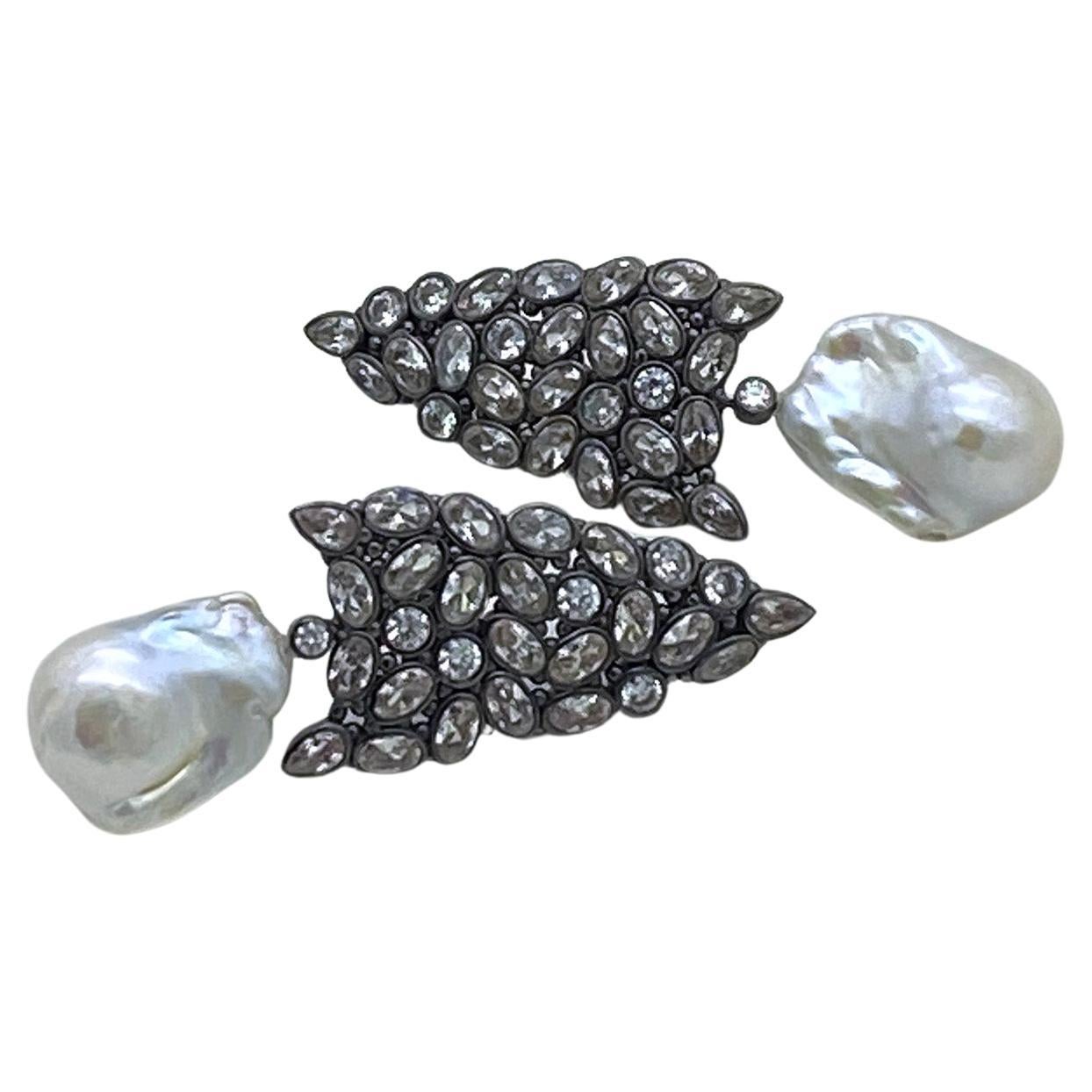 Il s'agit d'une paire de boucles d'oreilles en perles baroques et CZ. Les boucles d'oreilles en argent plaqué or noir sont composées de plusieurs formes de grappes de CZ serties dans un cadre en forme de pointe de flèche et de pendentifs avec une