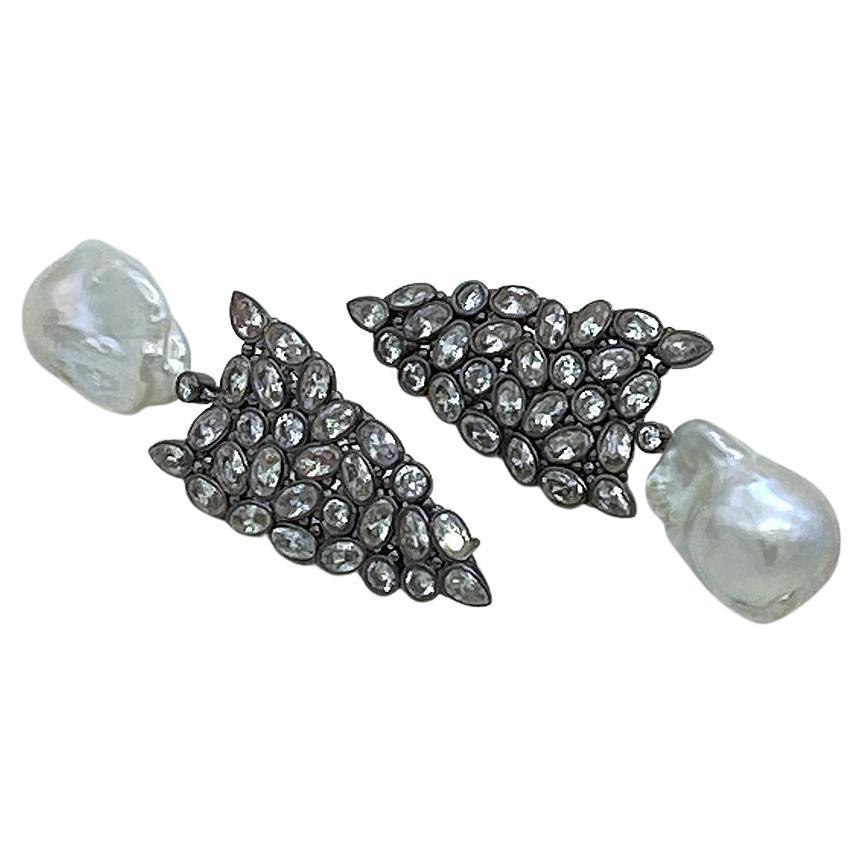 This is a pair of baroque pearl with CZ drop earrings. There are mutiple shapes of CZ clusters bezel set in black gold plated stering silver arrowhead shaped earrings plus dangles with a 15 x 25mm baroque pearl each.

Our vintage jewelry collection