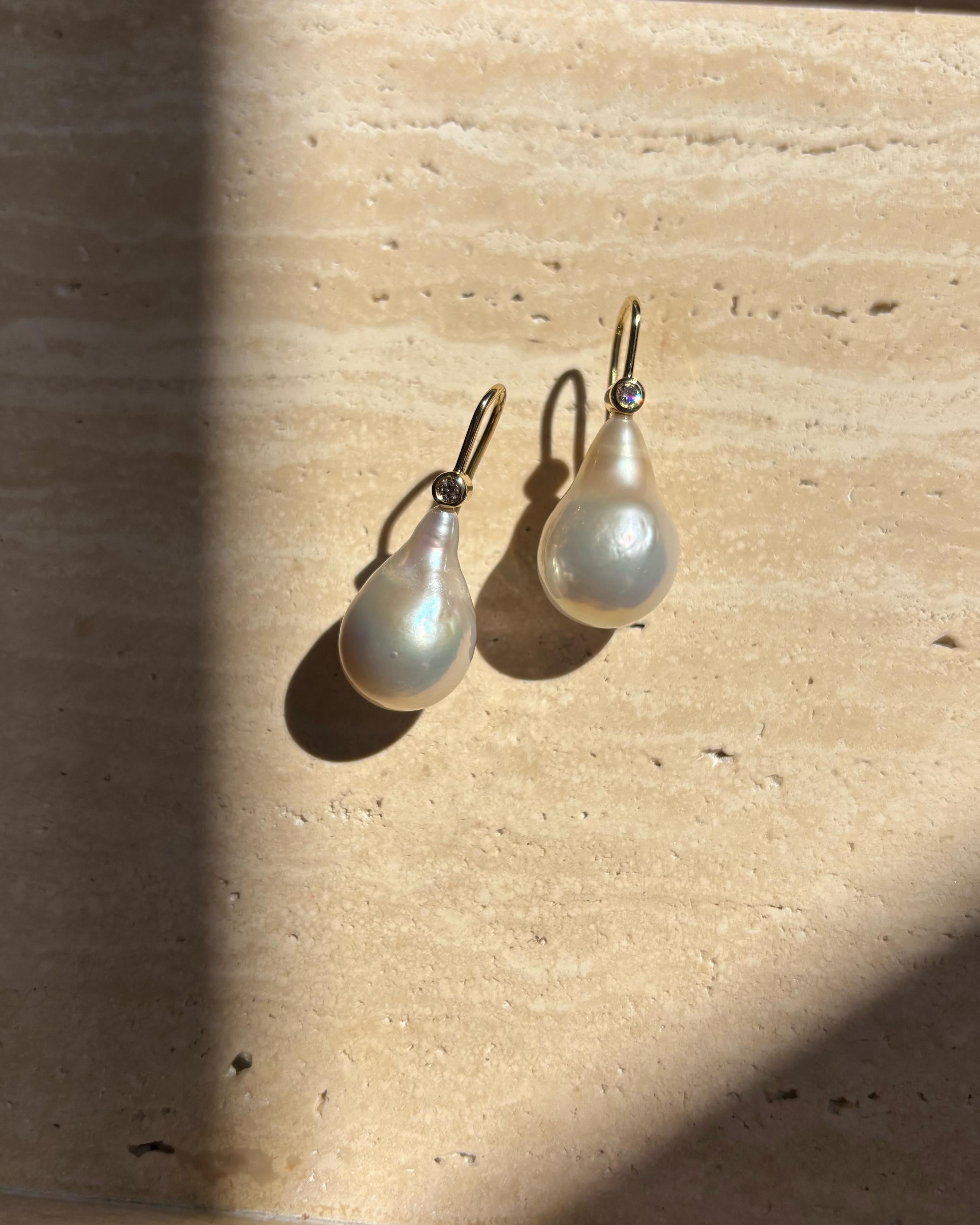 Questi splendidi orecchini presentano perle d'acqua dolce barocche e scintillanti diamanti naturali incastonati. Il design con gancio sottile assicura che siano facili da infilare e comode da indossare tutto il giorno. Grazie alla natura organica