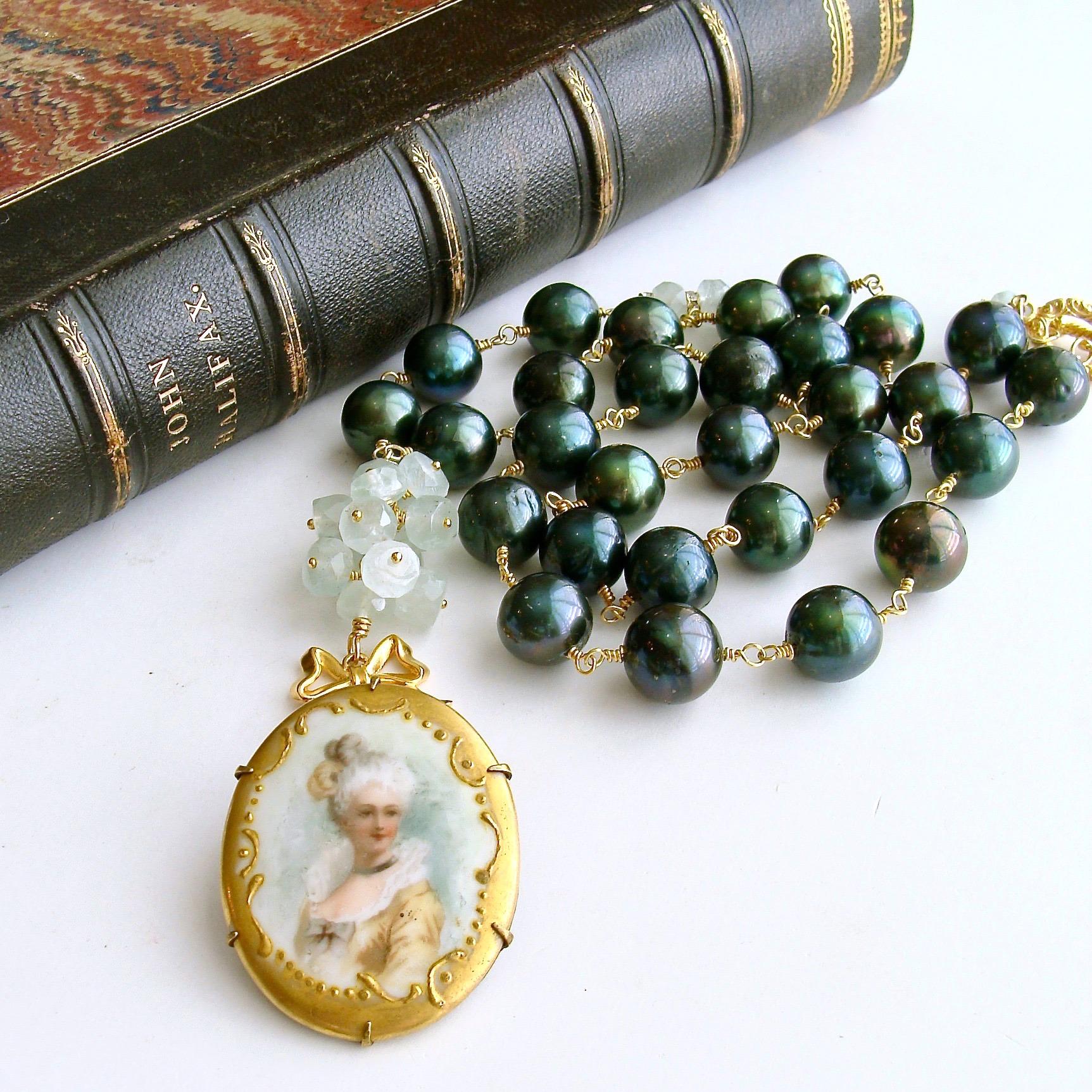 Marie’s Folly Necklace.

A beautiful hand painted porcelain brooch has become the focal point of this stunning necklace consisting of hand linked evergreen baroque pearls that gently accentuate the colors found in the hand painted portrait of this
