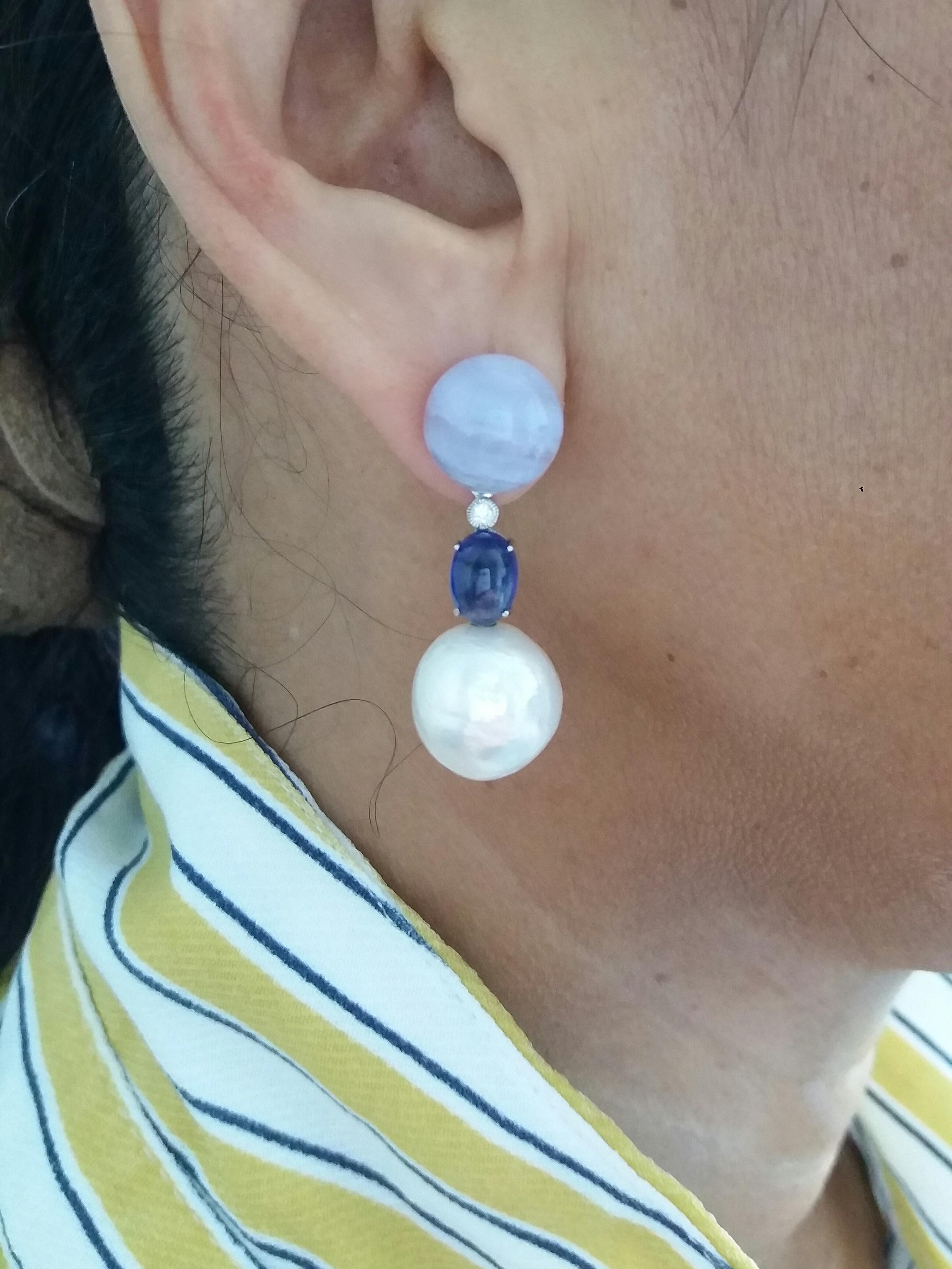 Round Chalcedony buttons on top, middle part in white gold,diamonds and oval blue sapphires,two baroque pearls of 13 mm in diameter
Total weigth  11 grams
Length 35 mm
Width 13 mm
In 1978 our workshop started in Italy to make simple-chic Art Deco