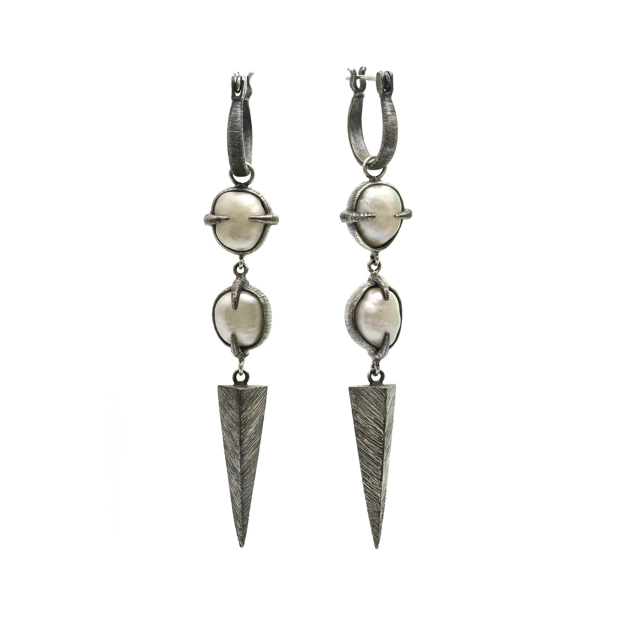 A pair of Baroque pearls clasped within textured and oxidised silver prongs that create a flow to which the eye is drawn to the end point of each earring. 
925 Sterling Silver, Etched & Oxidized
Free size Baroque Pearls
Size: 0,47