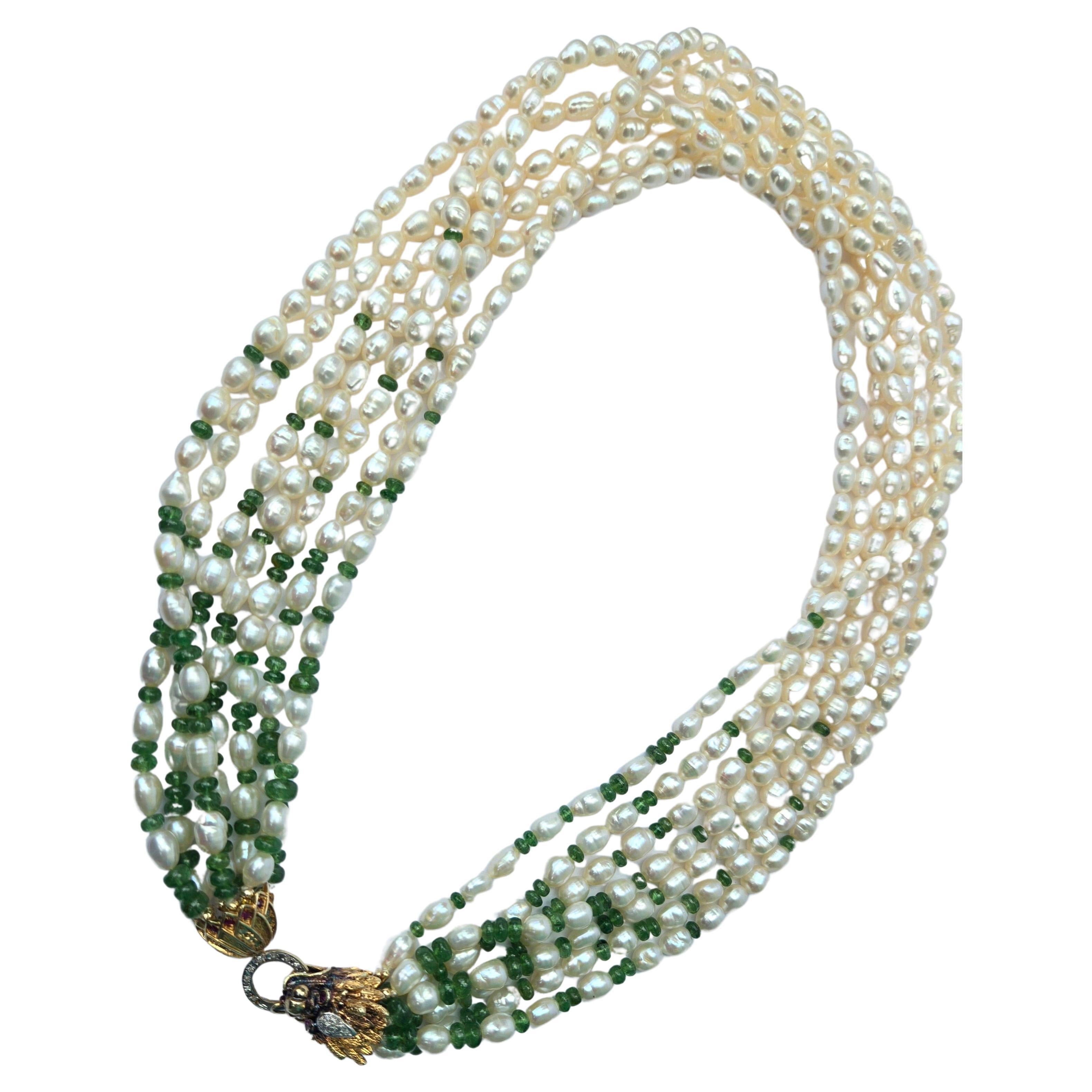 Necklace made up of seven strands of lovely oval cultured pearls. These are interspersed with a fade out of tumbled emerald beads from the beautiful vintage an exquisite gold dragon clasp. The clasp is patinated 14kt yellow and white gold set with