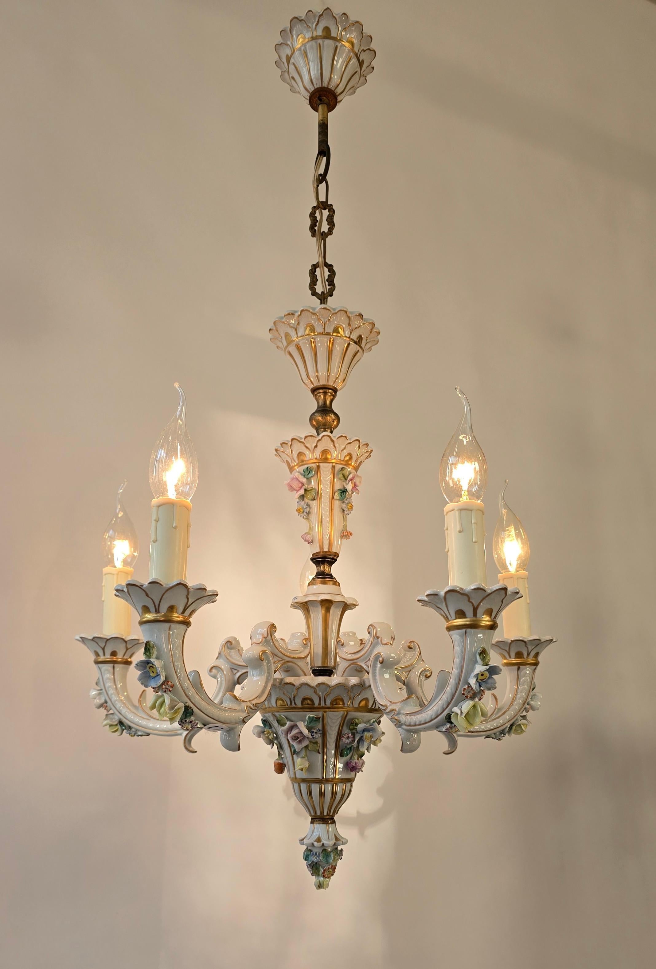 Exclusive Italian Porcelain Chandelier – Signed – Mid-20th Century.

This exquisite Italian porcelain chandelier from the mid-20th century is a true masterpiece of craftsmanship. Featuring delicately handcrafted floral decorations, elegant gilded