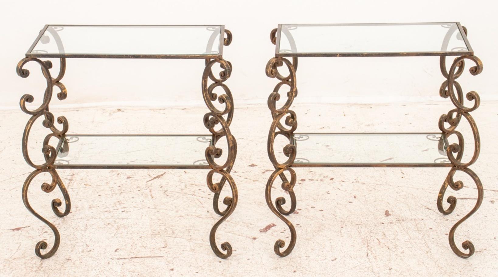 Pair of Baroque Revival partially gilt wrought iron side tables, with scrolling legs conjoined by stretchers beneath rectangular glass tops.

Dimensions: 23