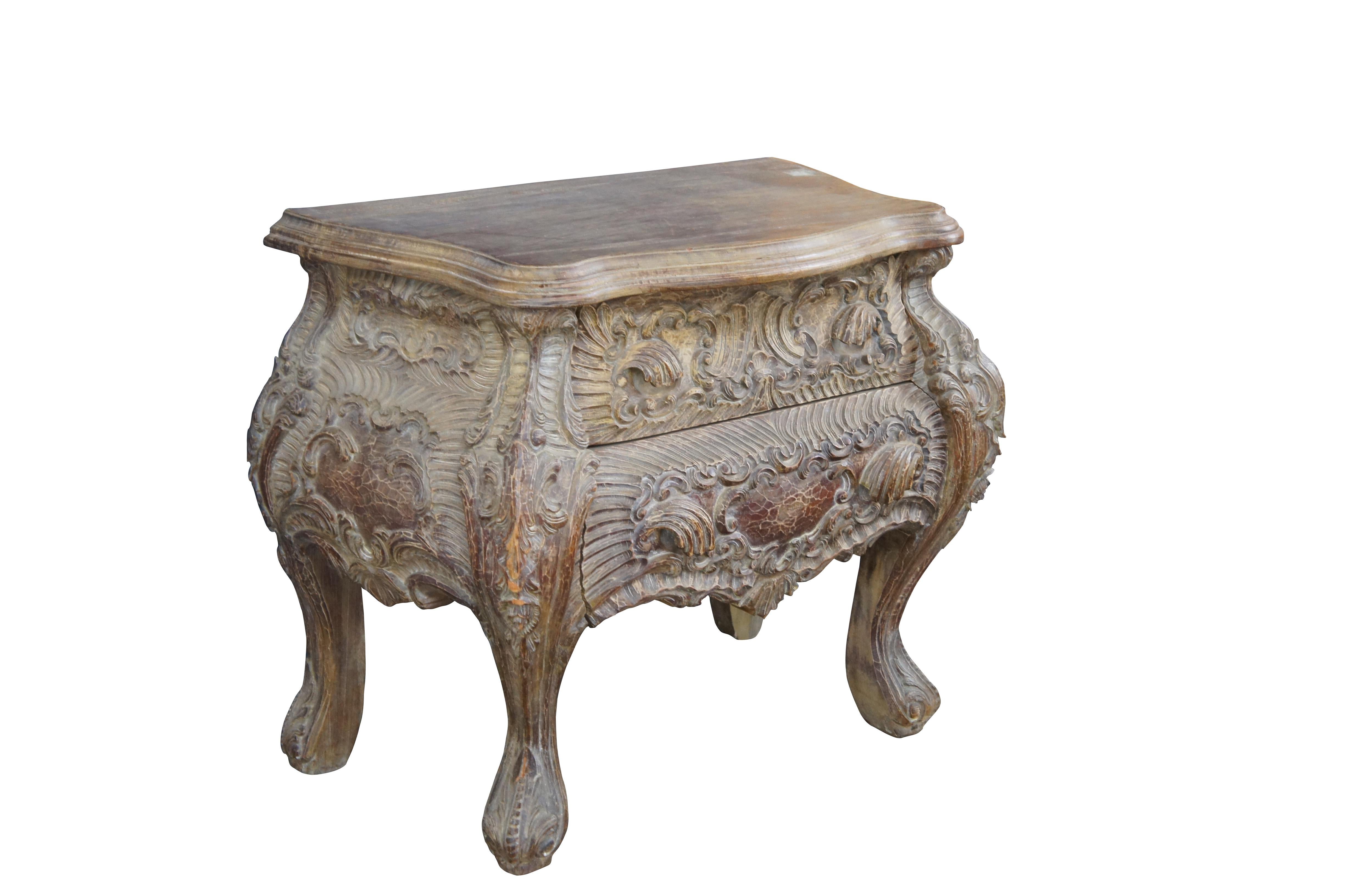 Baroque Revival carved wooden nightstand / commode. Features a serpentine frame with two drawers, heavily carved in baroque manner with cabriole legs. Great for use as a bedside table, Bombay / commode, nightstand, end or side