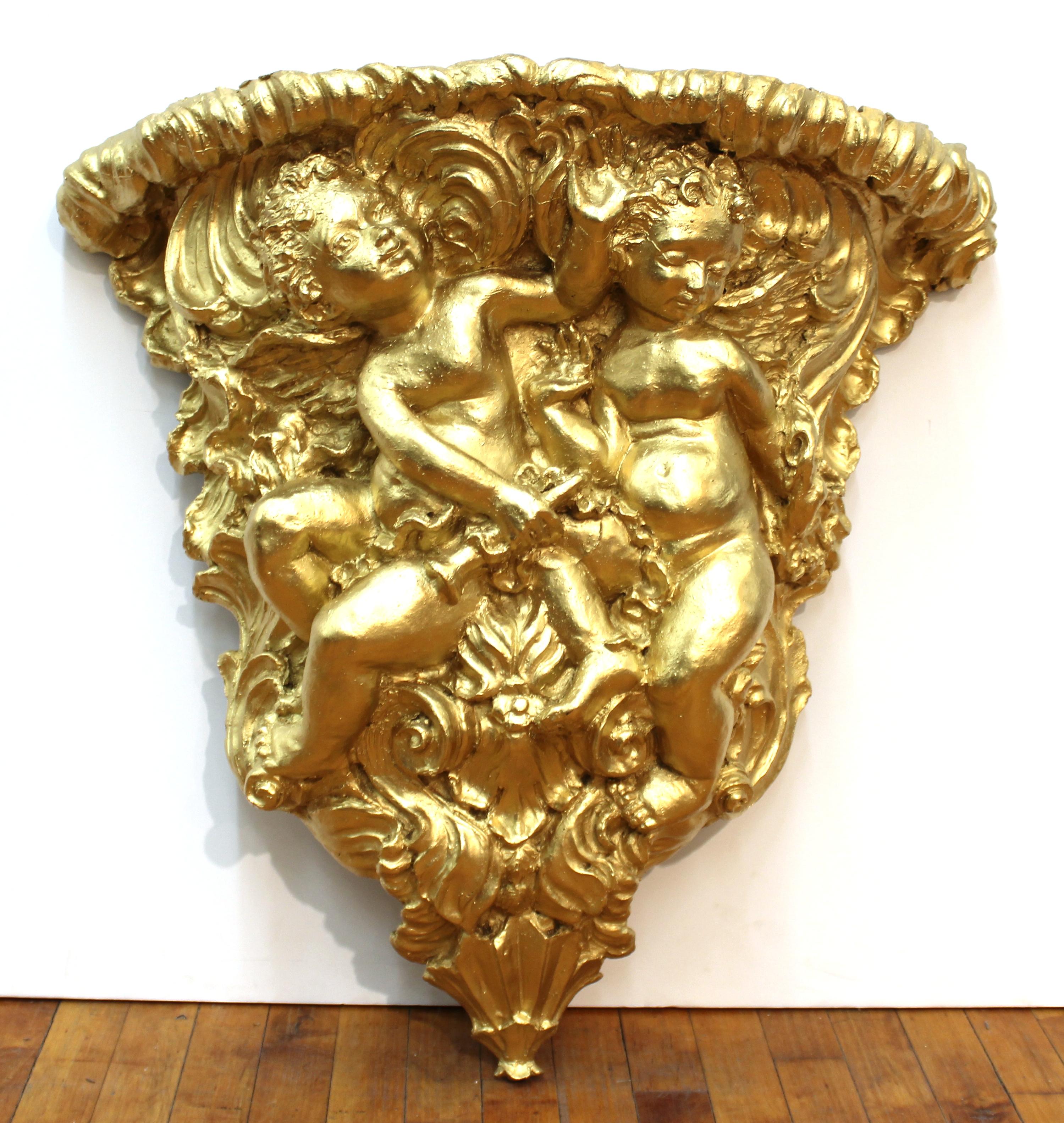 Baroque or Rococo Revival style gilt large wall bracket with frolicking putti, molded in resin.