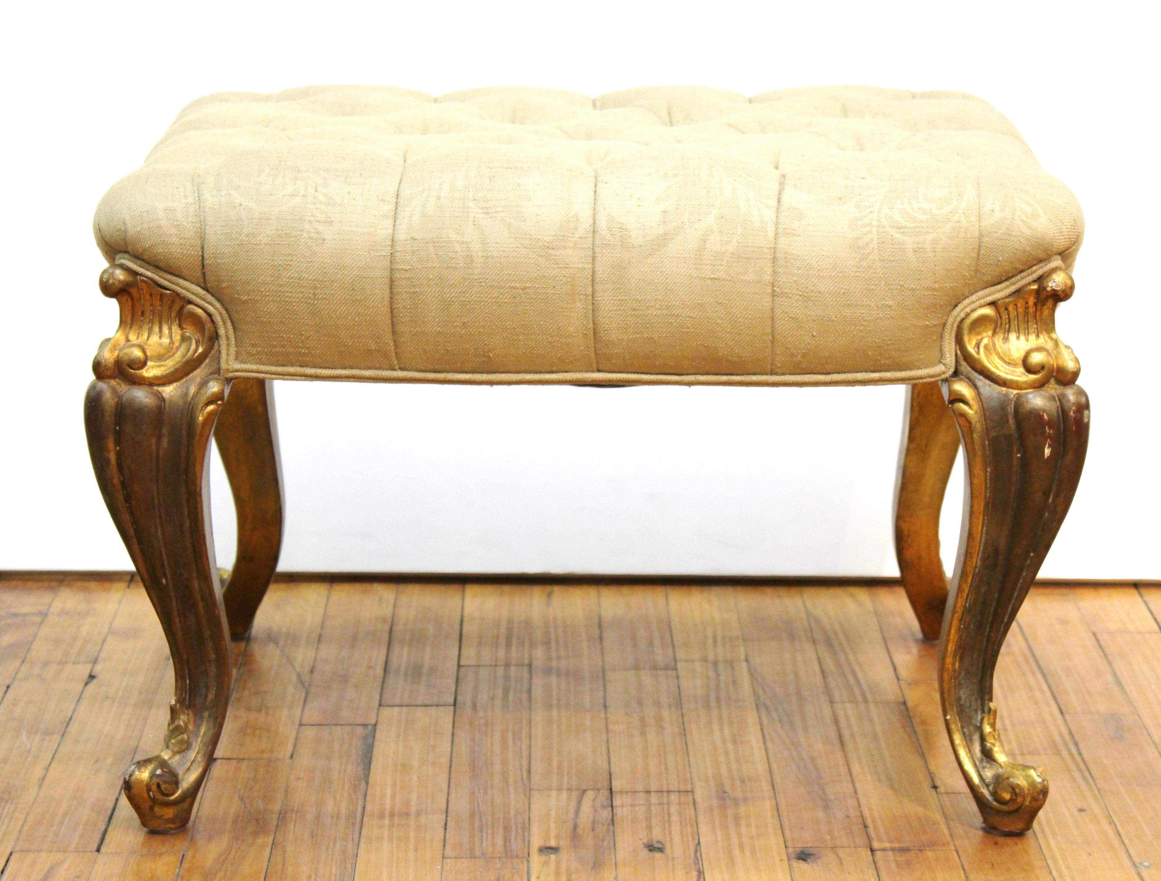 Baroque Revival style upholstered ottoman with carved and giltwood legs. In great vintage condition with age-appropriate wear and use.
