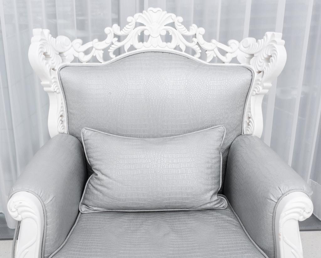 Baroque Revival white arm chair, of a heavily carved body, upholstered in silver-gray faux alligator skin, unmarked.

Dimensions: 42.5