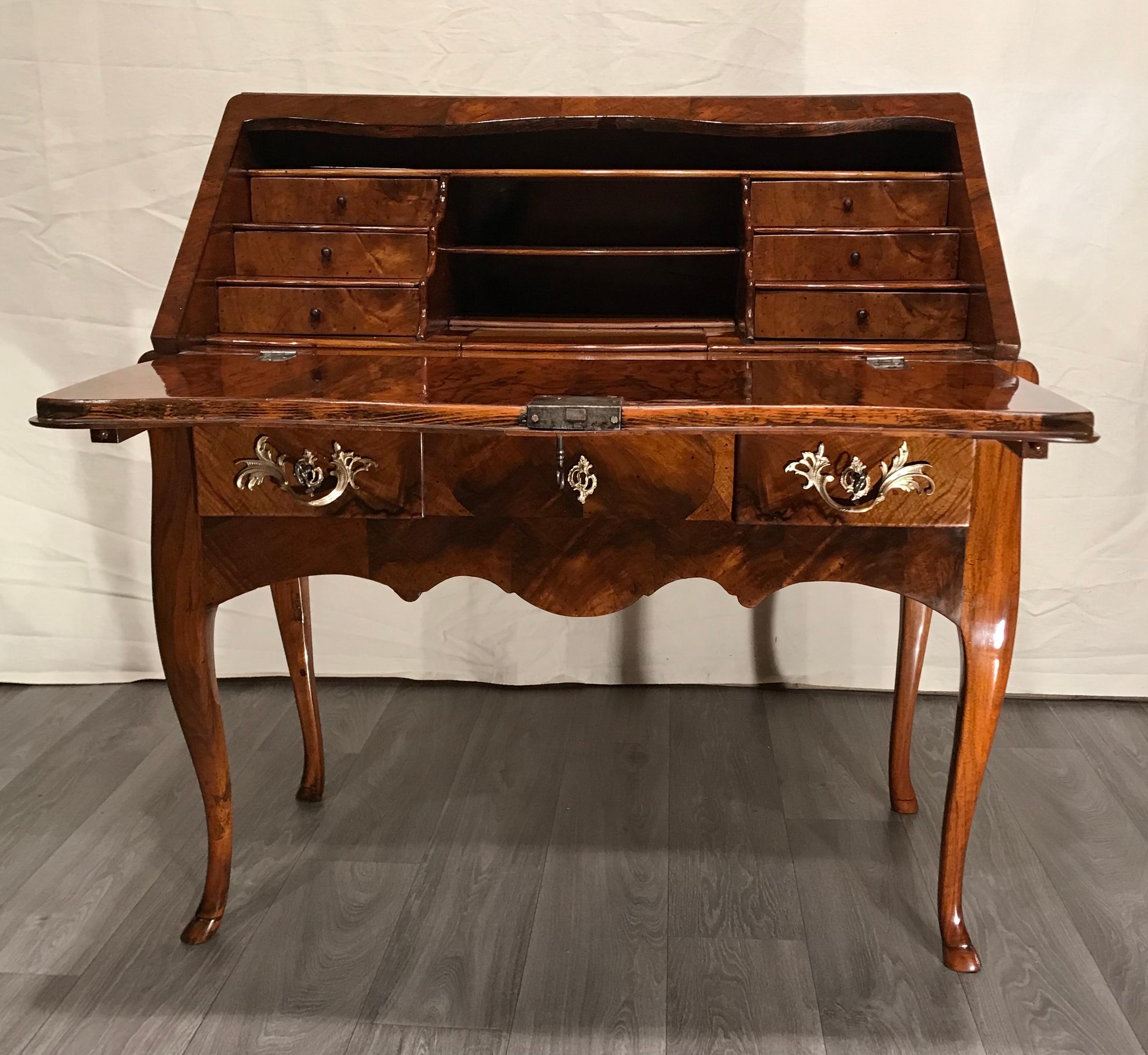 Baroque secretary desk, Switzerland, 1750.
This gorgeous baroque secretary desk stands out for its very pretty walnut veneer. The writing flap opens to an elegant interior with various small drawers and open and secret compartments. The writing