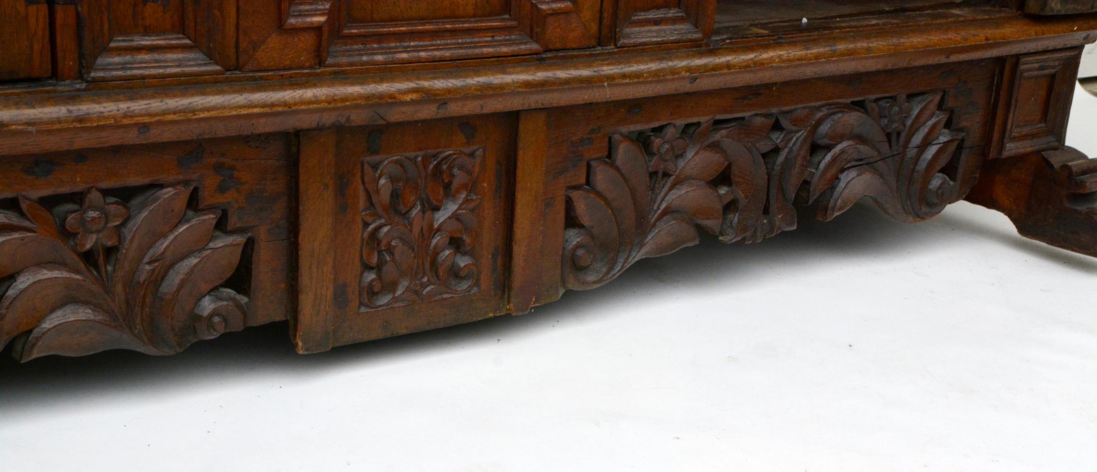 Baroque Sideboard, northern Germany, 1750s. Made of solid oak.

Cut out and protruding skid feet. Very richly floral carved apron, partly openwork. The three-door corpus is divided by four ribbons with geometric caskets. Two full-height doors with